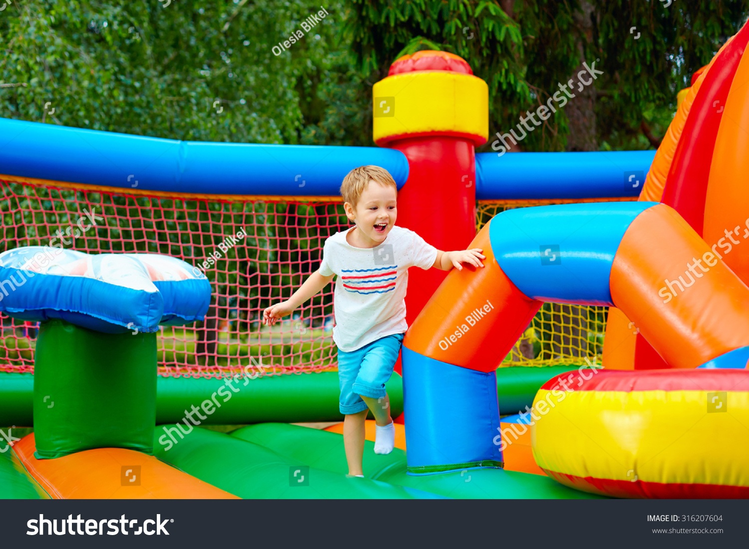happy excited boy having fun on inflatable attraction playground #316207604