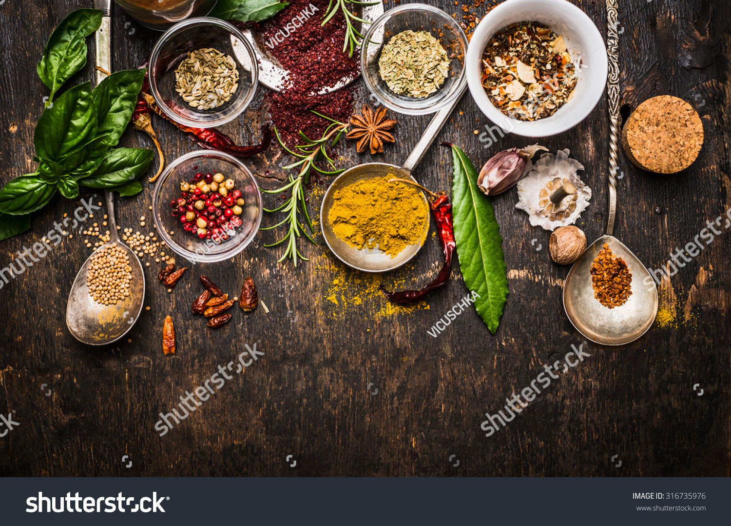 Dry colorful  spices in spoons and bowls with fresh seasoning on dark rustic wooden background, top view, border #316735976