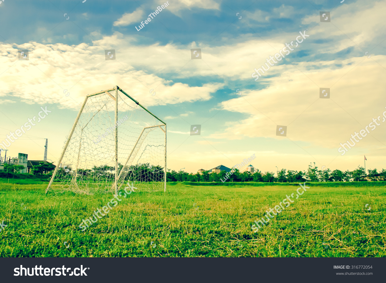 Goal post on grass football playground viewed from ground level with sky.Used color tool for vintage tone. #316772054