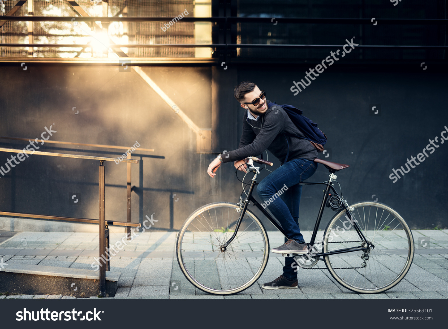 A young stylish businessman going to work by bike.  #325569101