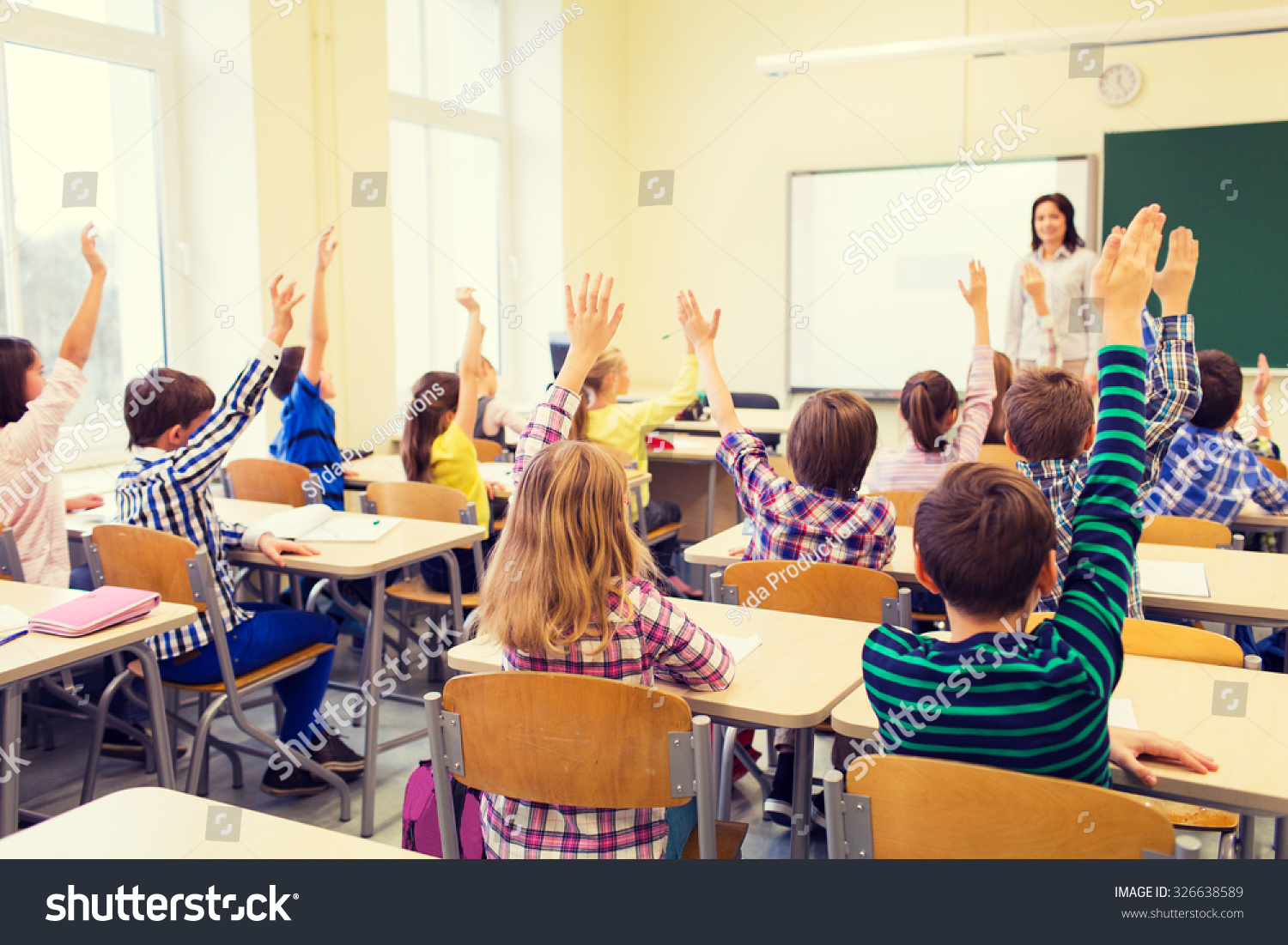 education, elementary school, learning and people concept - group of school kids with teacher sitting in classroom and raising hands #326638589