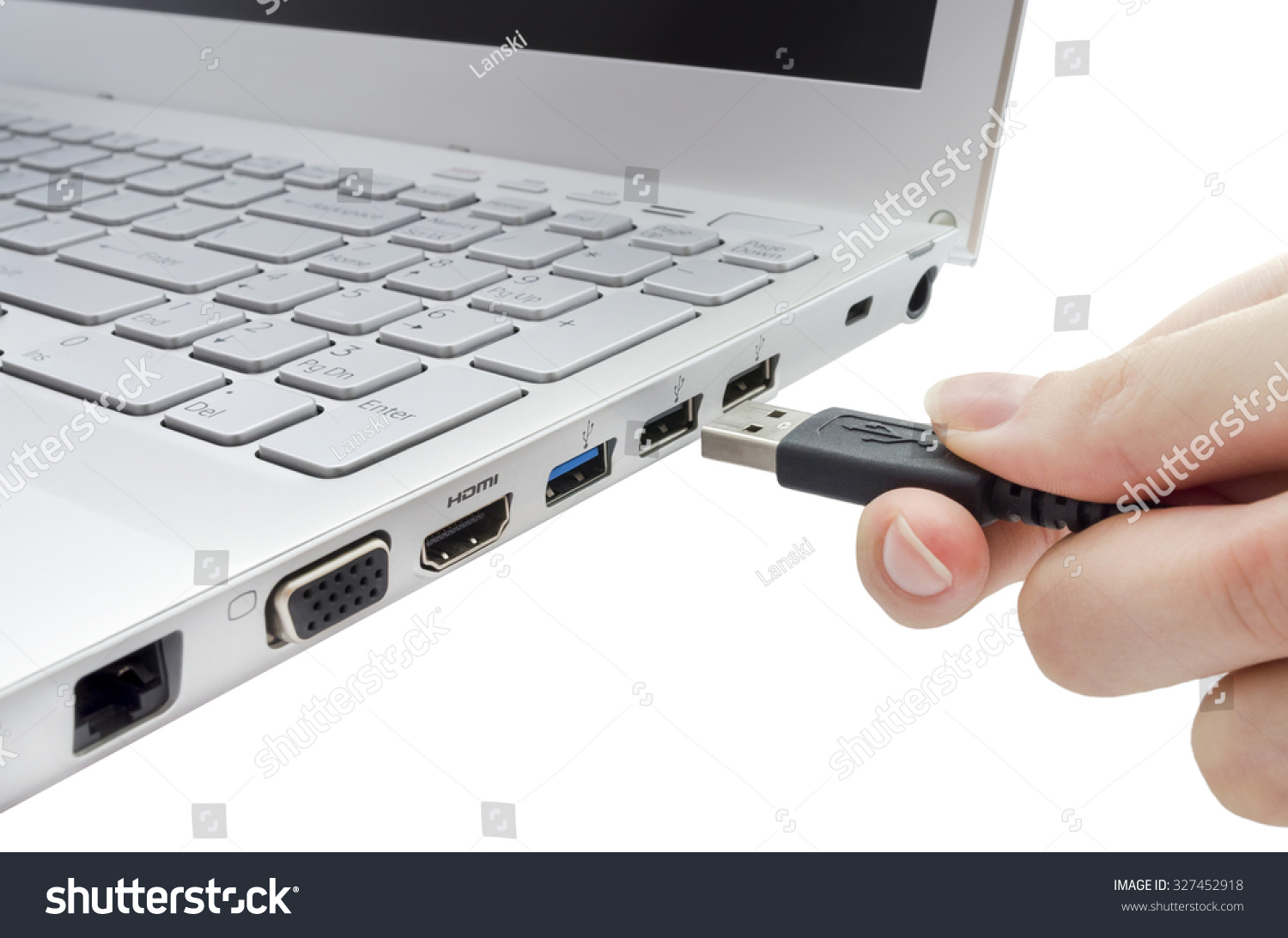 Hand inserting black USB cable into laptop isolated on white background #327452918