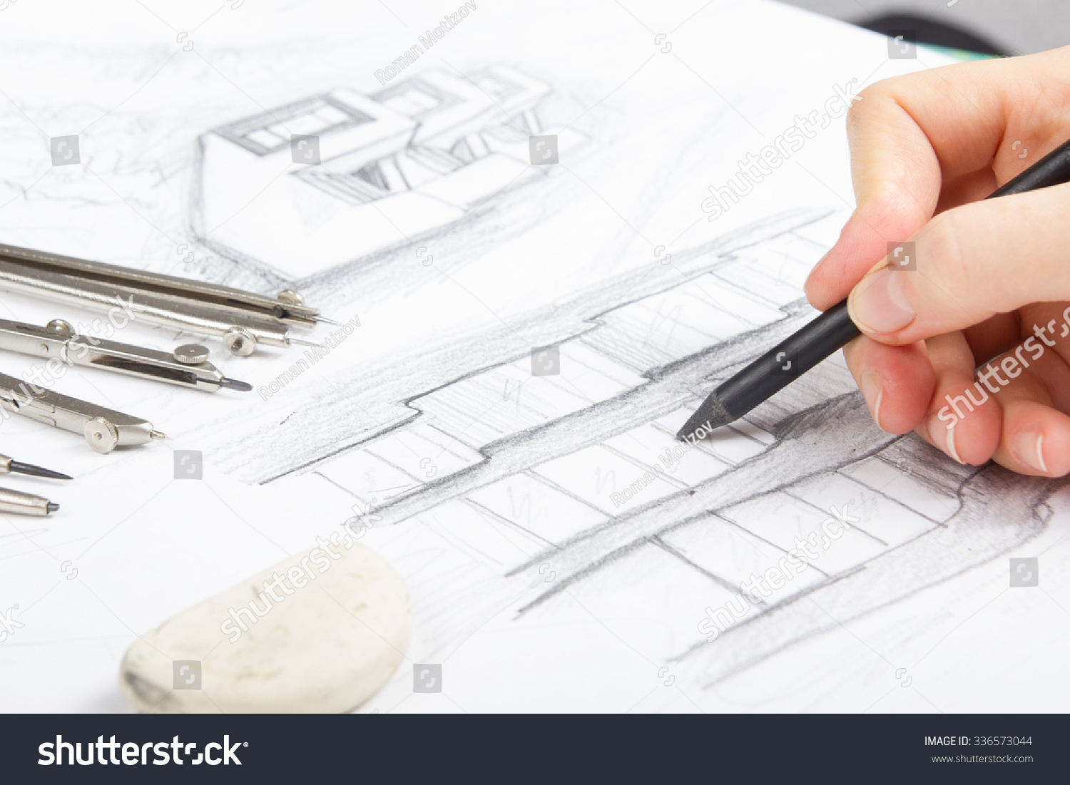 Architect working on blueprint. Architects workplace - architectural project, blueprints, eraser, pencil and divider compass. Construction concept. Engineering tools #336573044