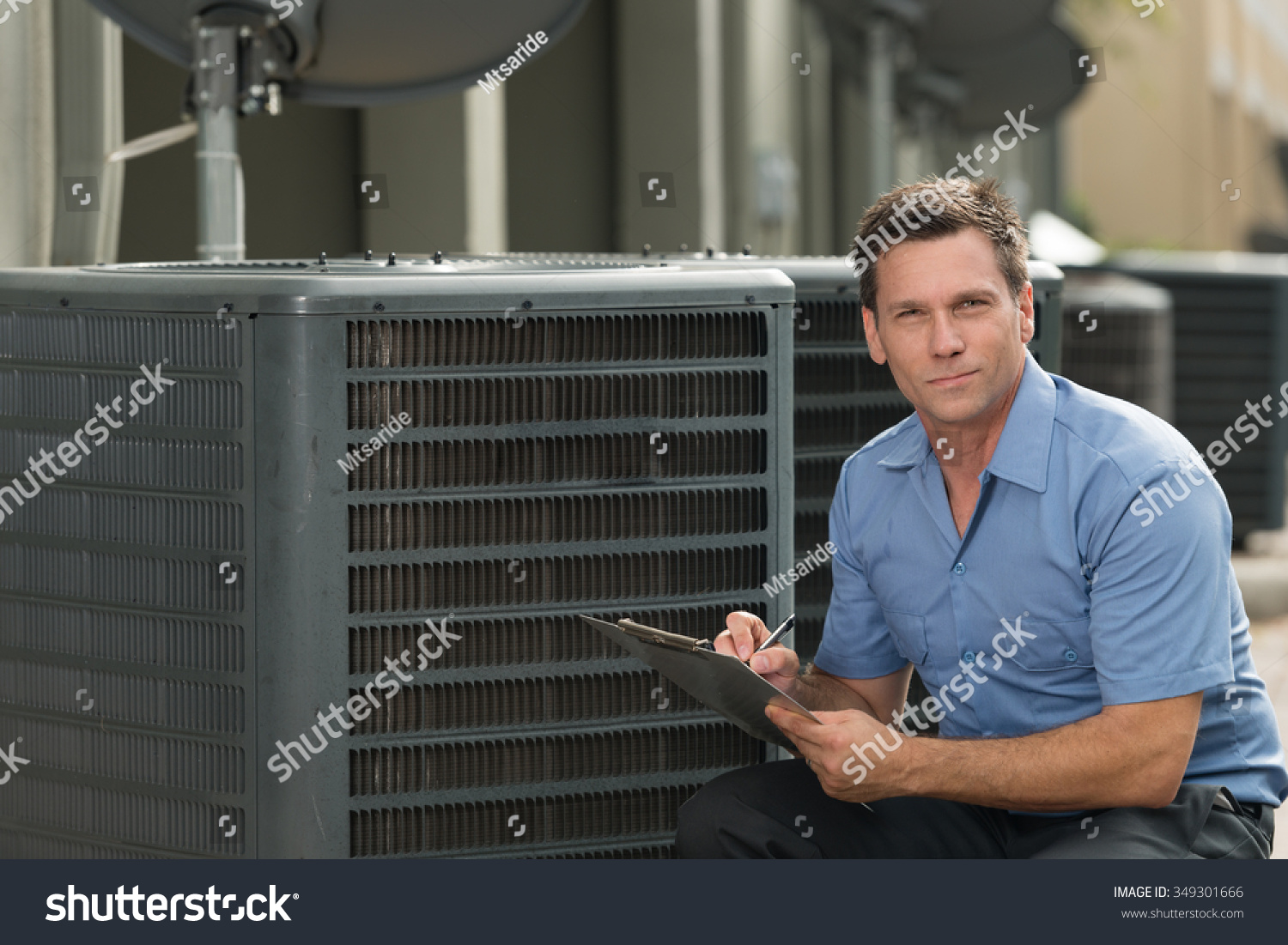 Thirtyish air conditioning repairman with clipboard #349301666