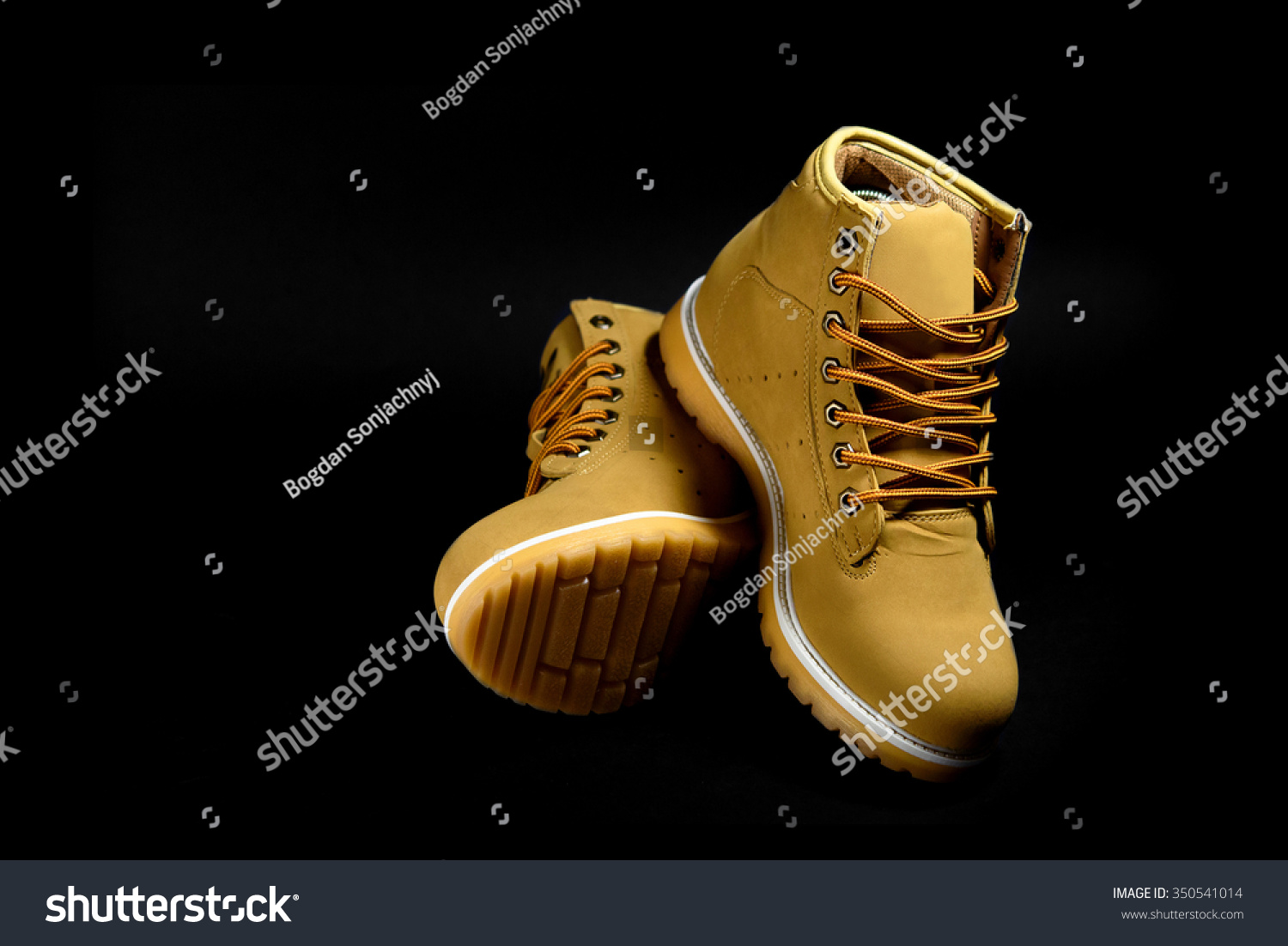 stylish yellow nubuck mens boots on black background, advertising concept #350541014