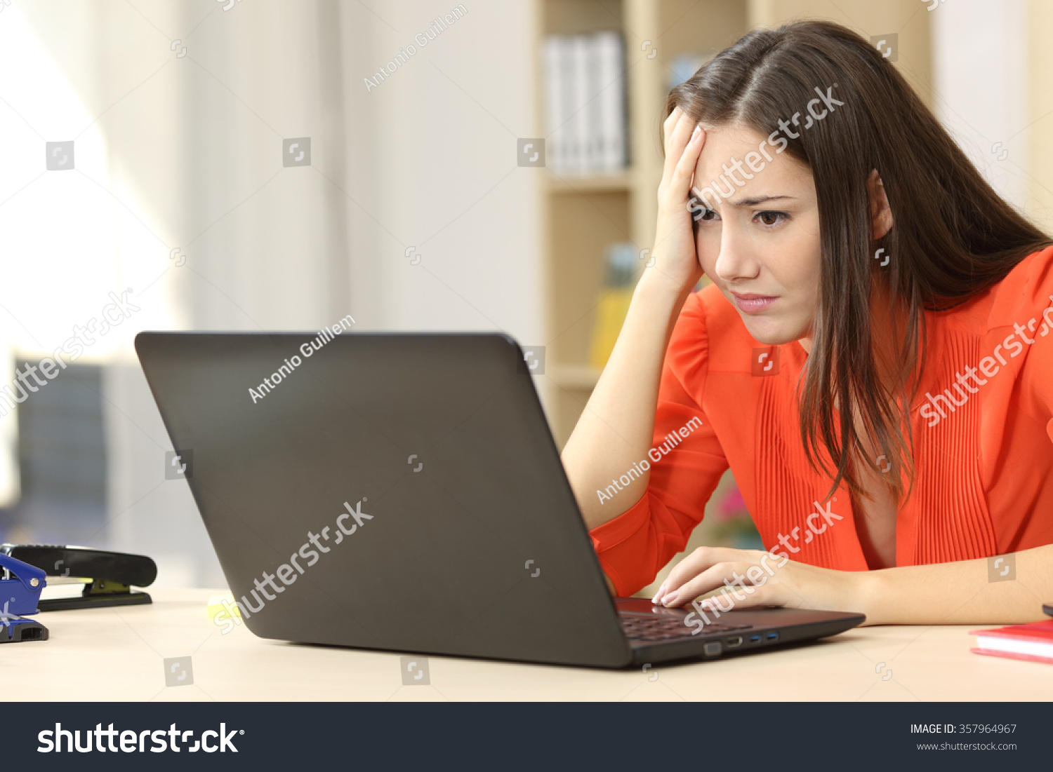 Sad and worried entrepreneur working on line with a laptop in an office desk or home #357964967