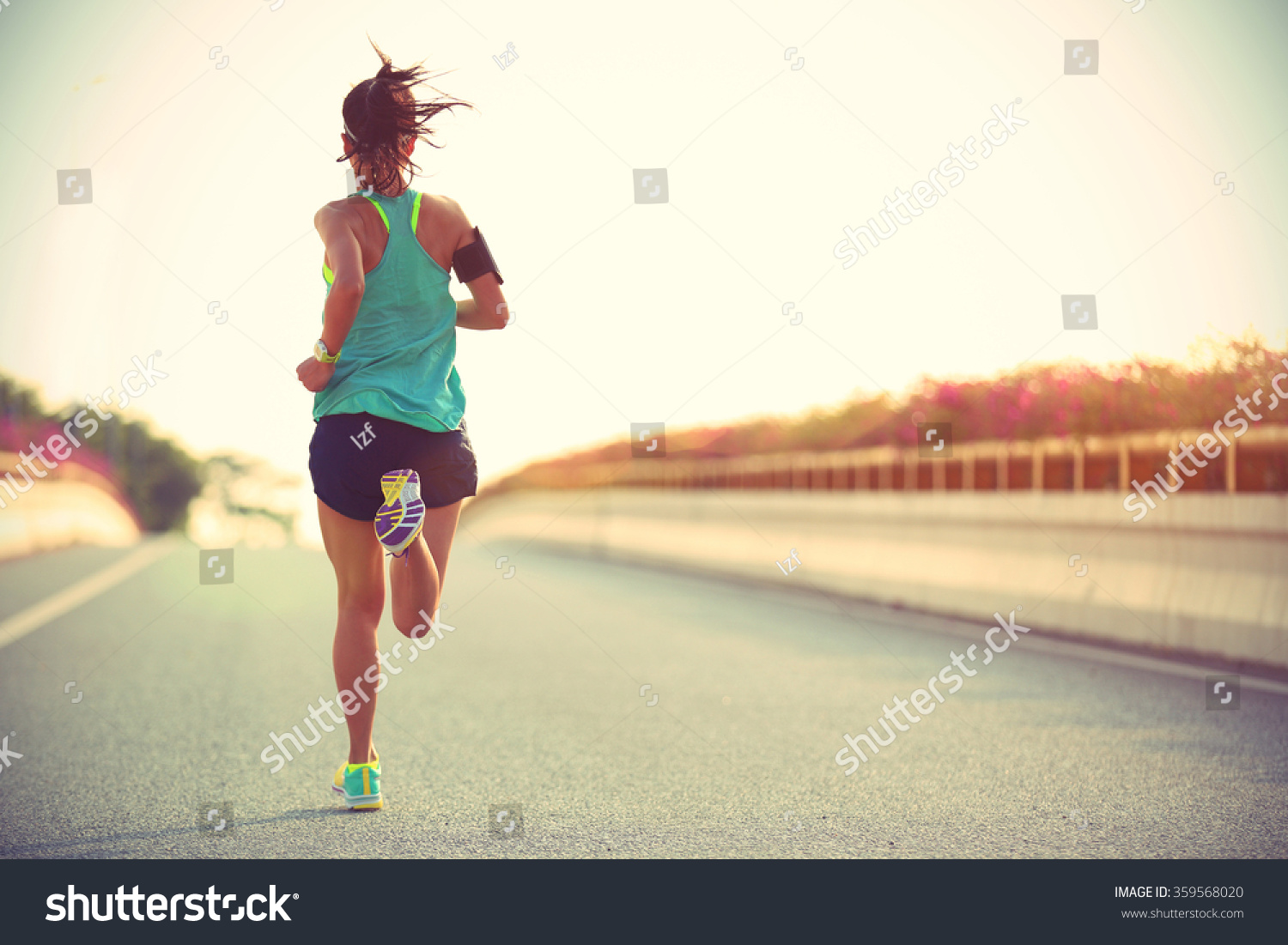 Young woman runner running on city bridge road #359568020