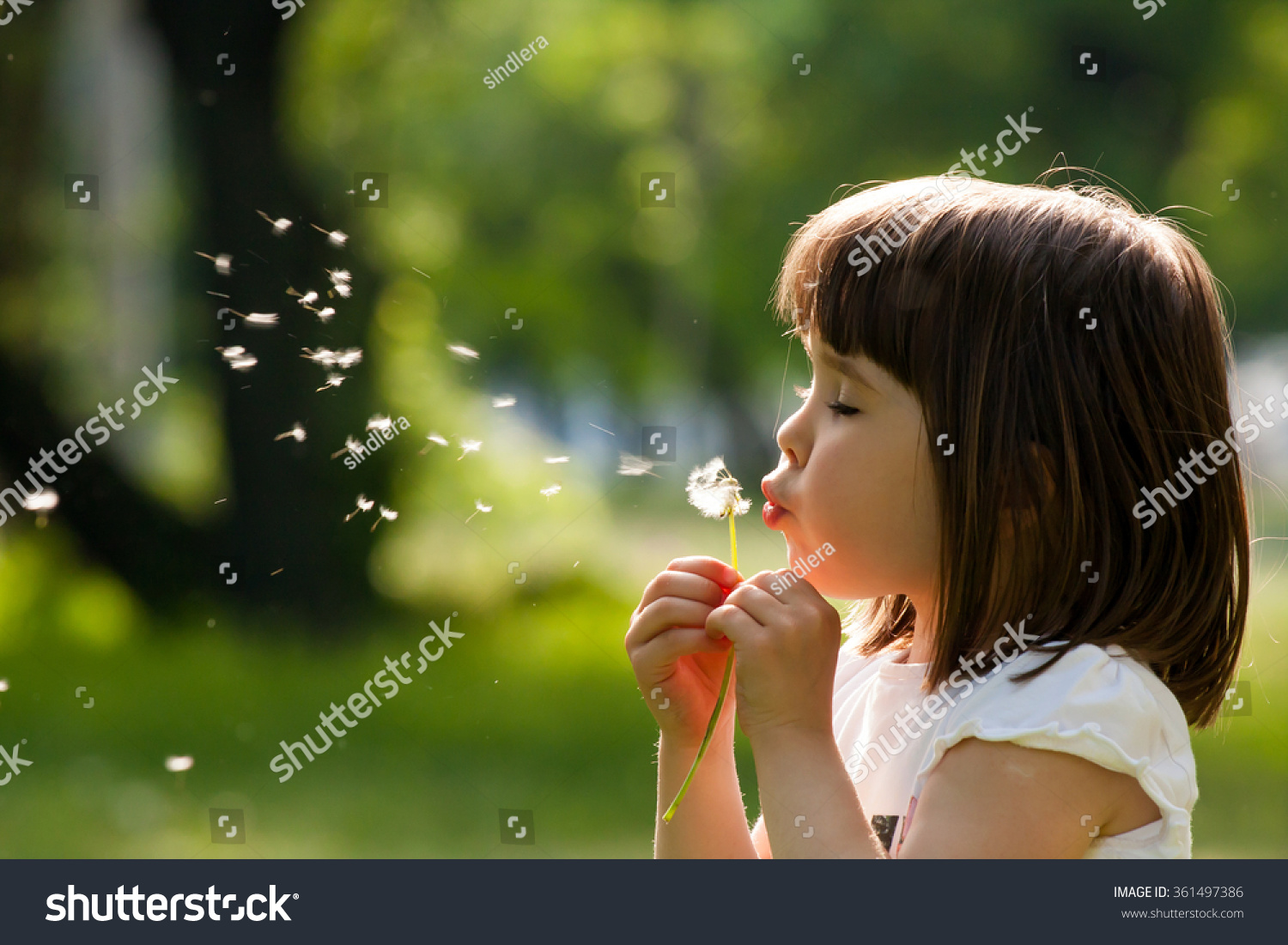 Beautiful child with dandelion flower in spring park. Happy kid having fun outdoors. #361497386