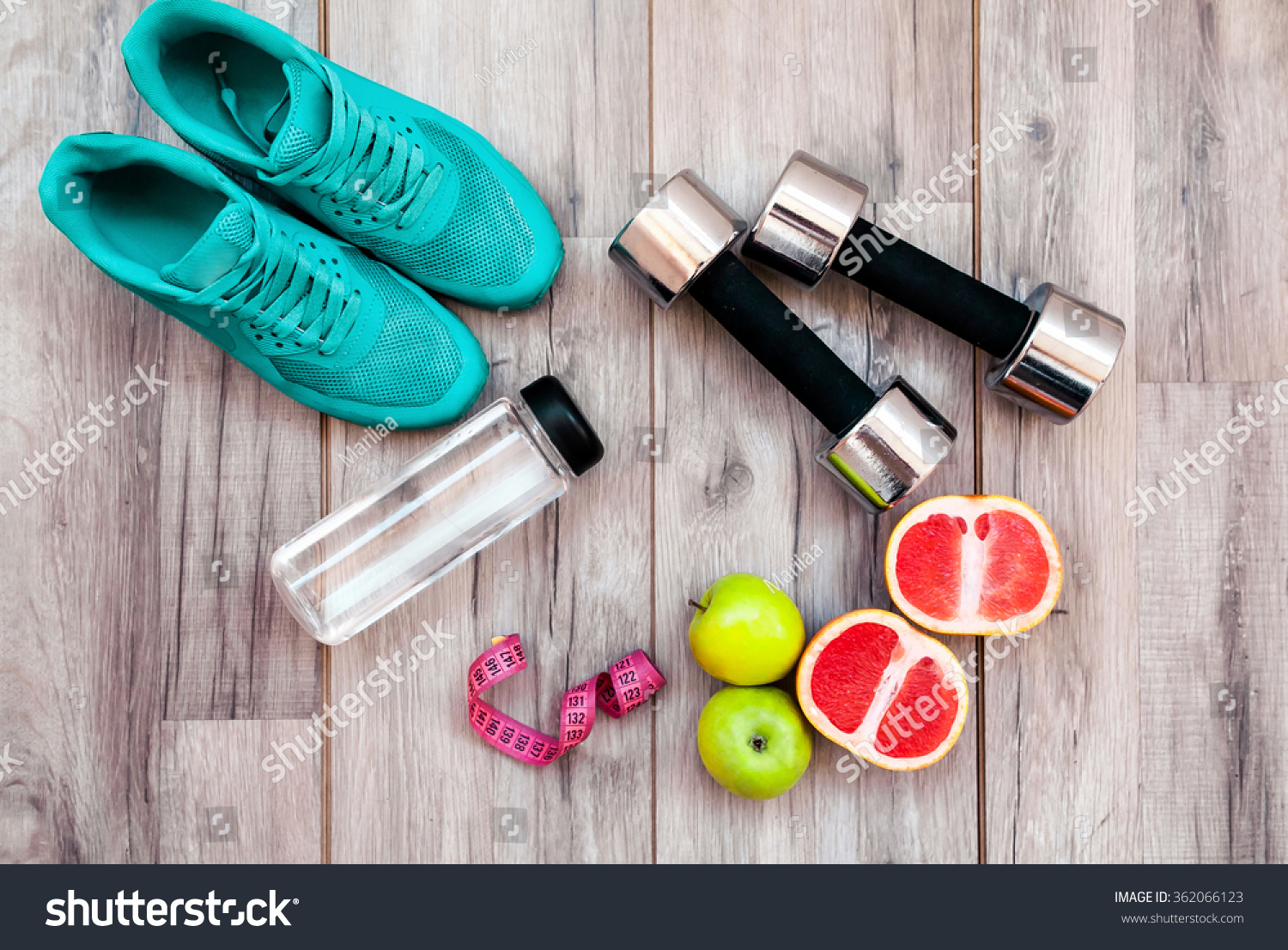 Fitness equipment. Healthy food. Sneakers, water,apple  on wooden background #362066123