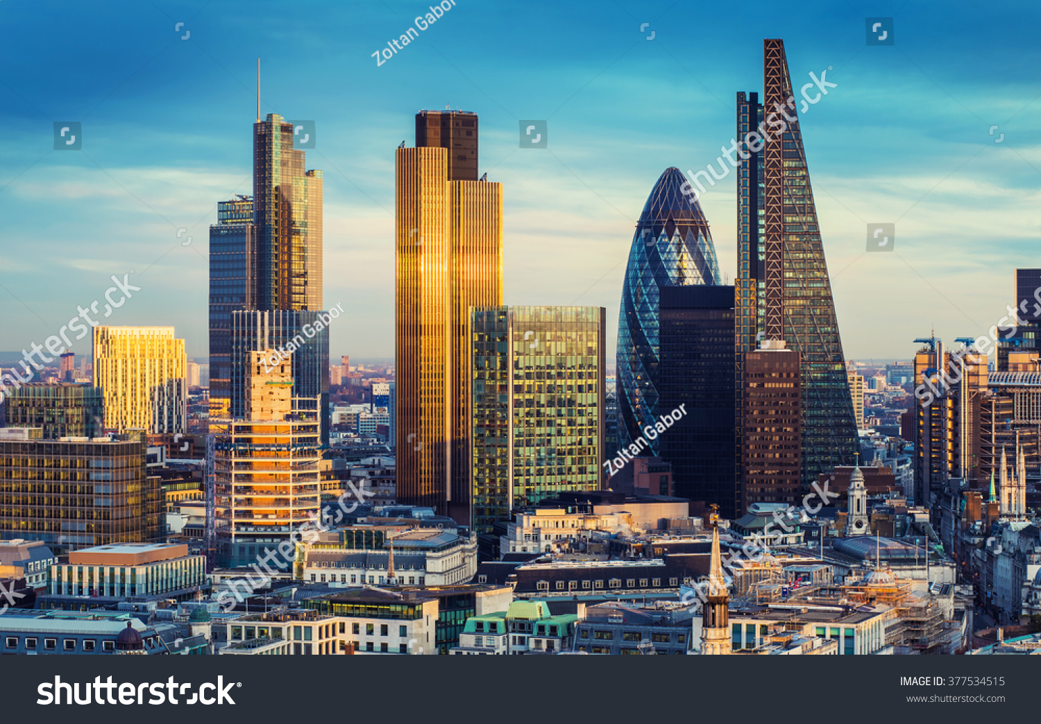 London, England - The bank district of central London with famous skyscrapers and other landmarks at sunset with blue sky - UK #377534515