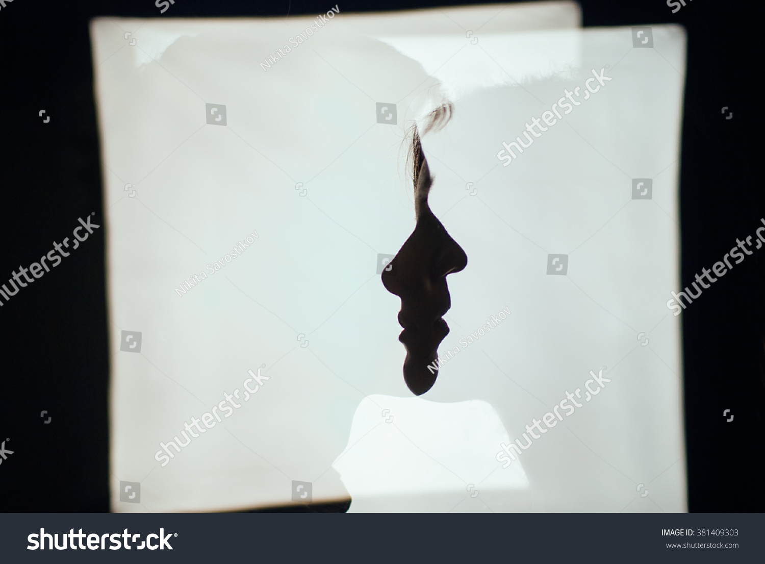 A silhouette photograph of a couple: shadows of a boy and a girl in each other on white background #381409303