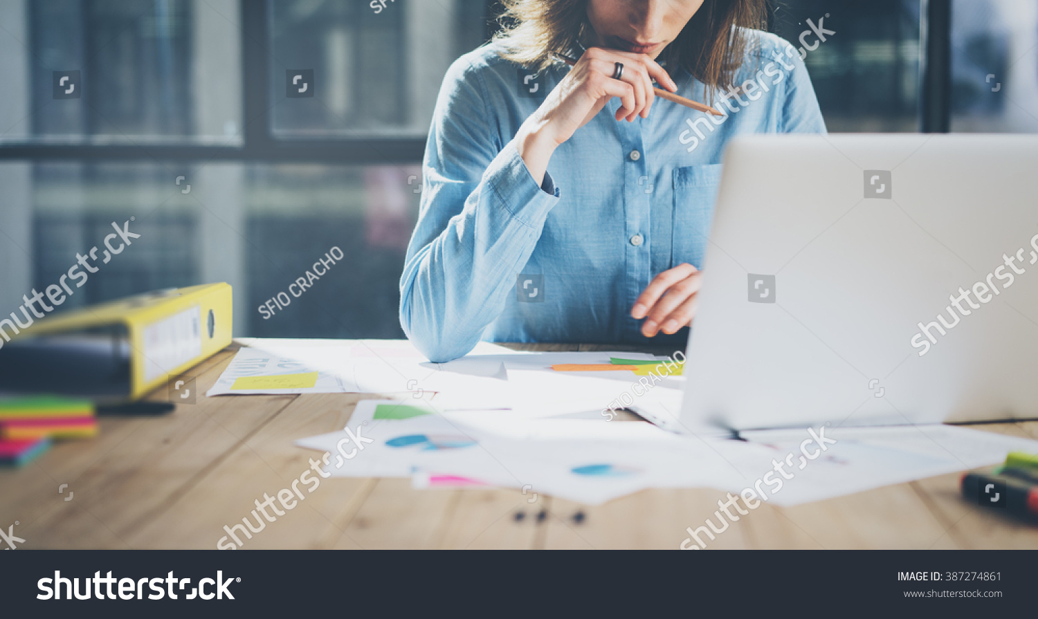 Young architect work project. Photo woman working with new startup project in modern loft. Generic design notebook on wood table. Horizontal, film effect #387274861