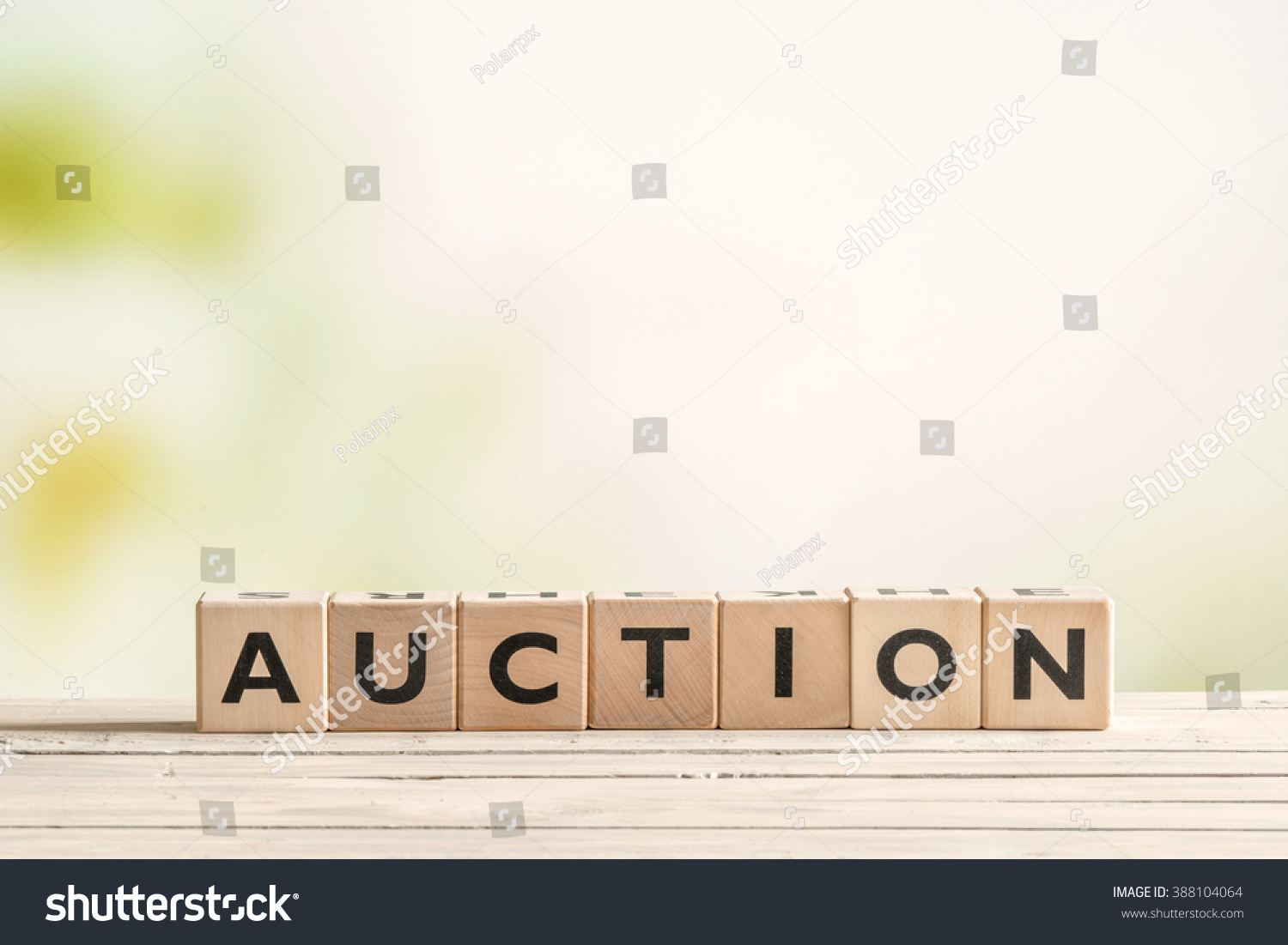 Auction sign on a vintage table on green background #388104064