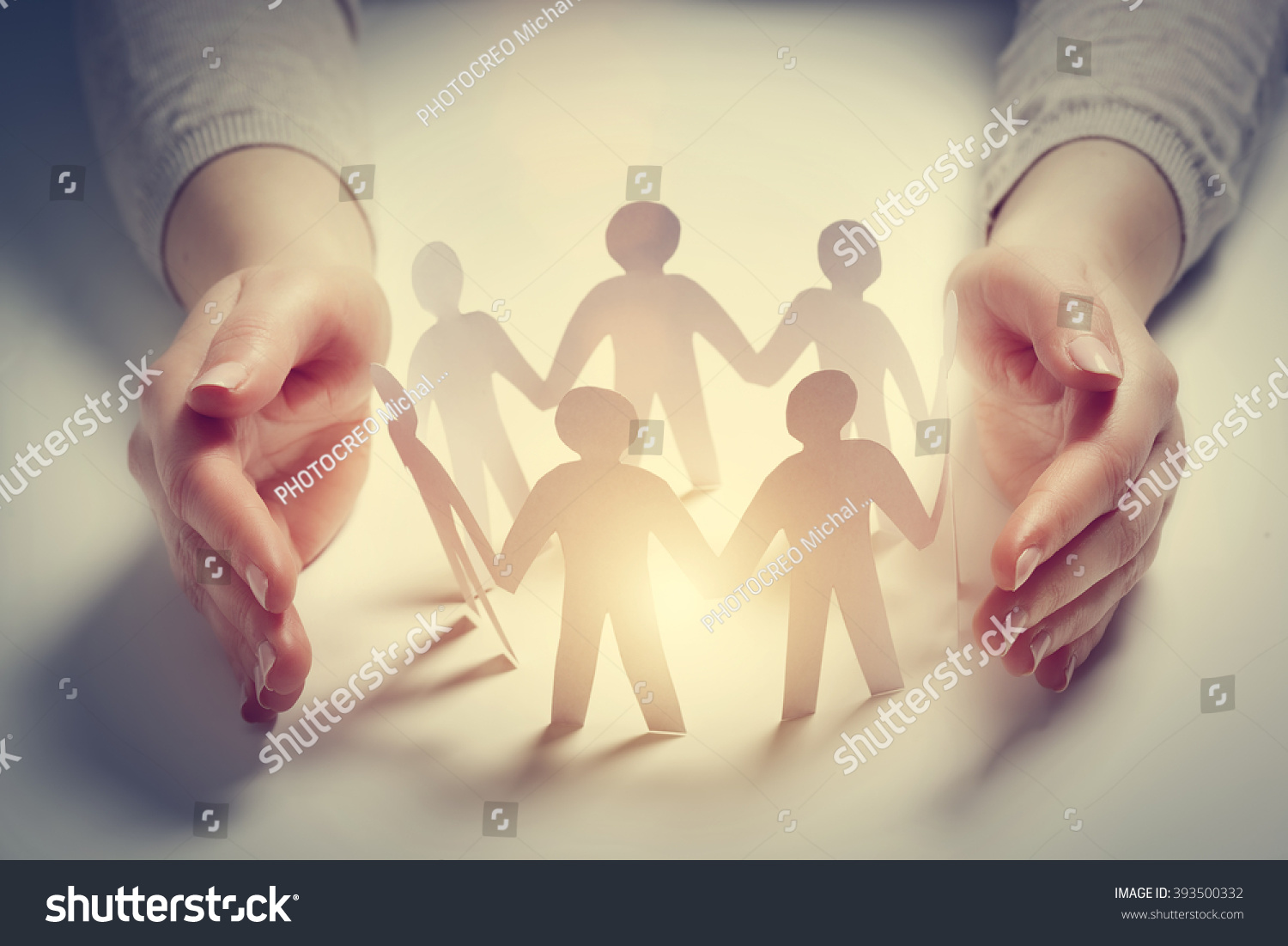 Paper people surrounded by hands in gesture of protection. Concept of insurance, social protection and support.  #393500332