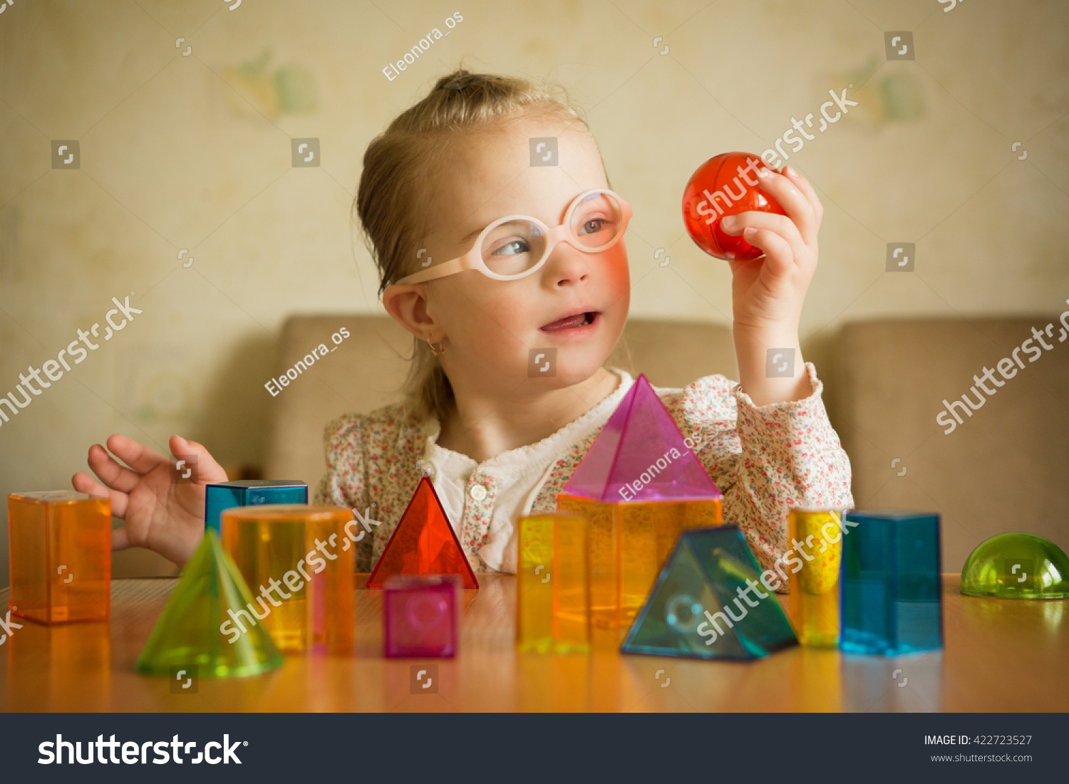 Girl with Down syndrome playing with geometrical shapes #422723527