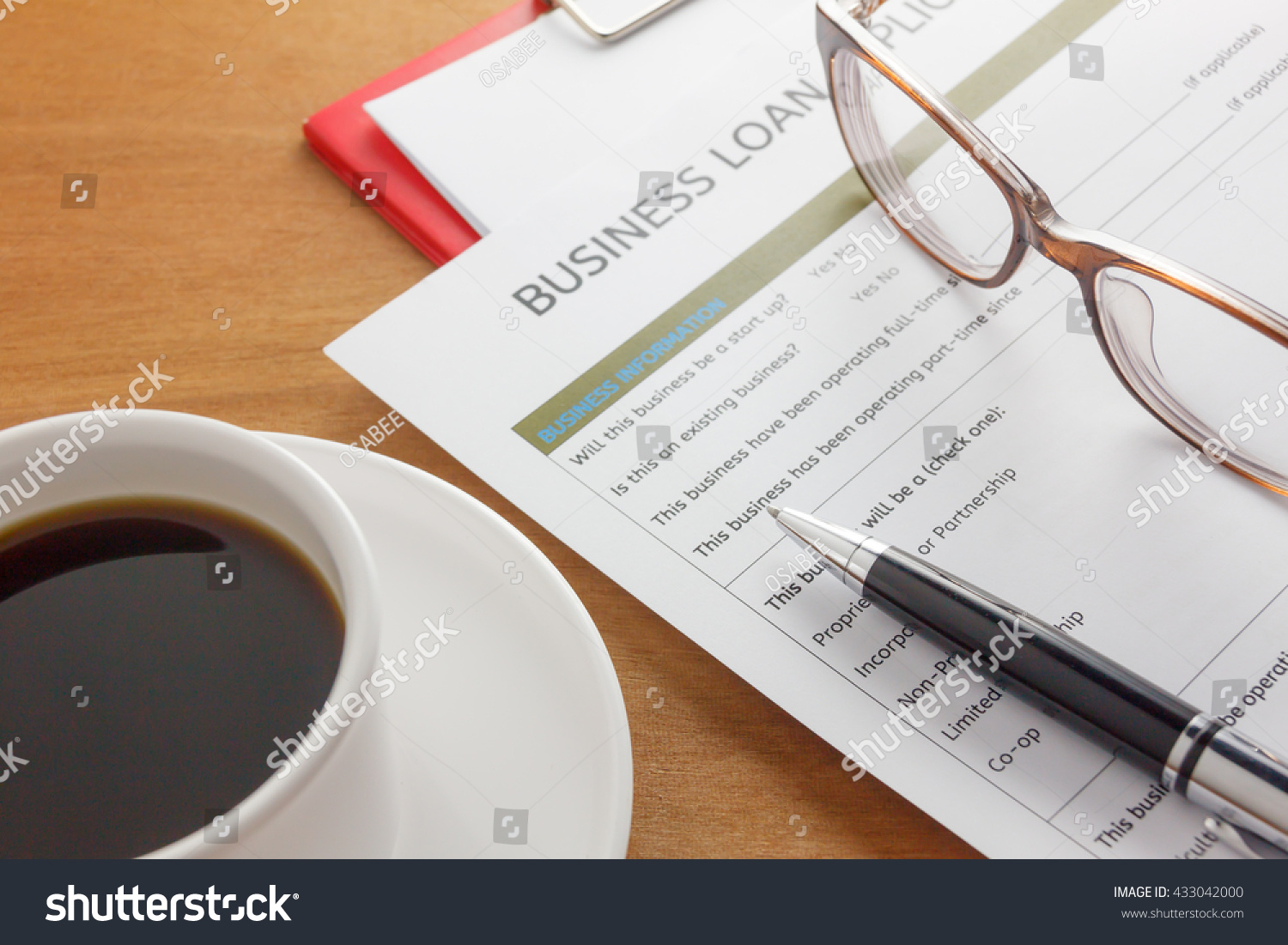 pen,Business loan application form,coffee,glasses,paper clip on wood business background. #433042000