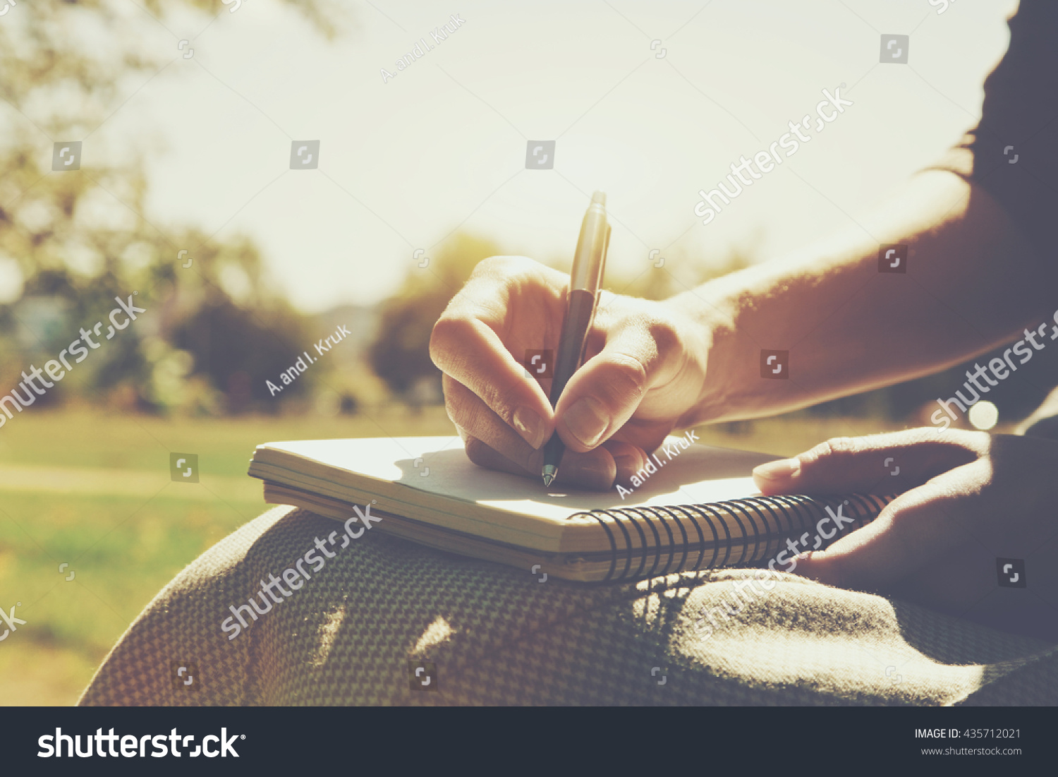 girls hands with pen writing on notebook in park #435712021