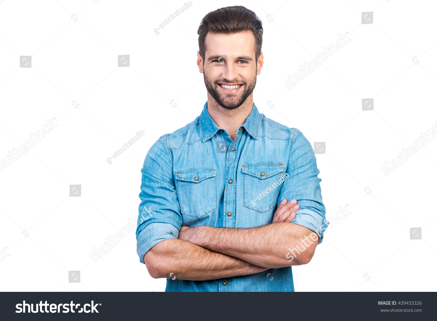 Casually handsome. Confident young handsome man in jeans shirt keeping arms crossed and smiling while standing against white background  #439433326