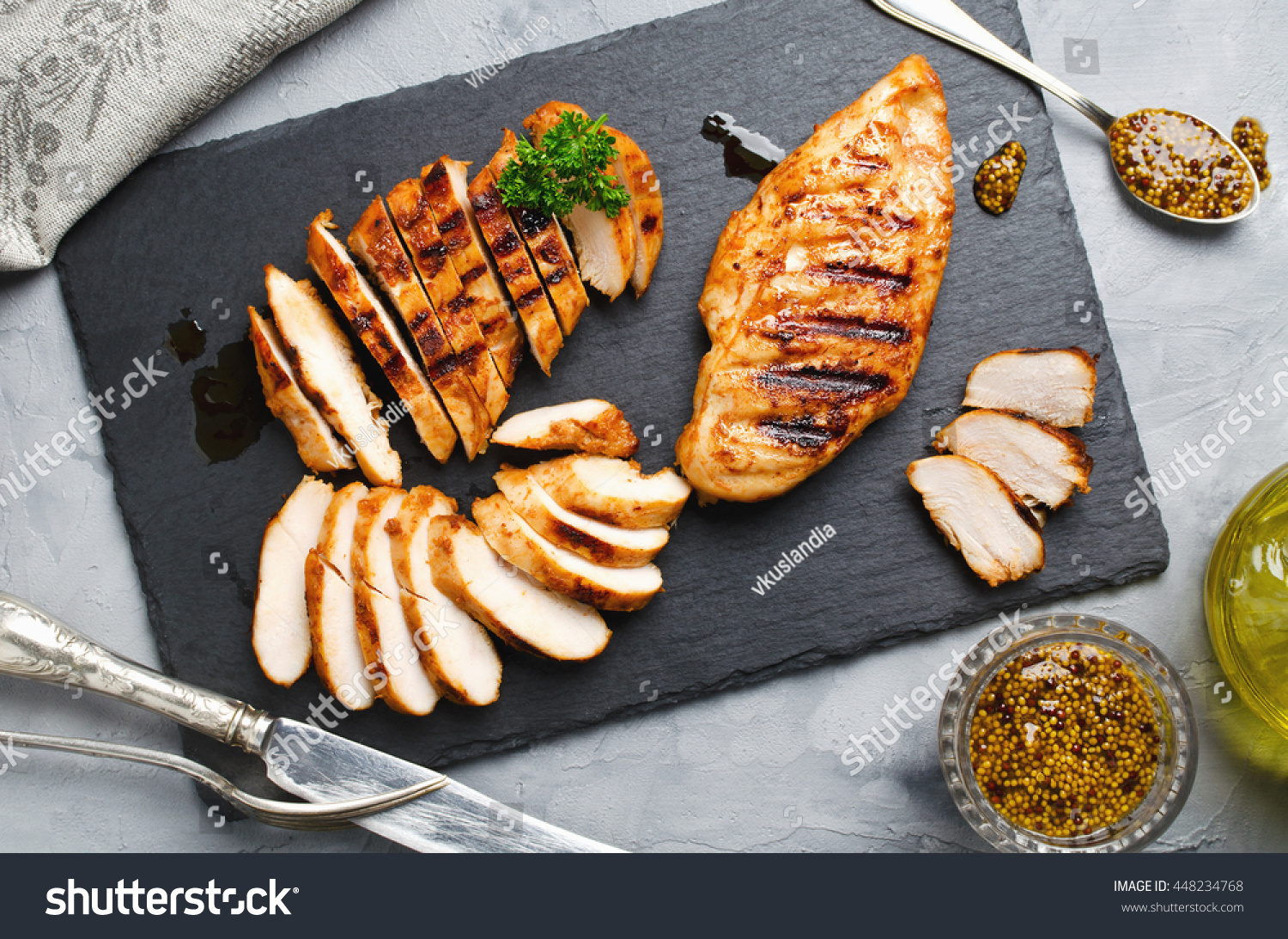 Grilled chicken fillets on slate plate. Gray concrete background #448234768