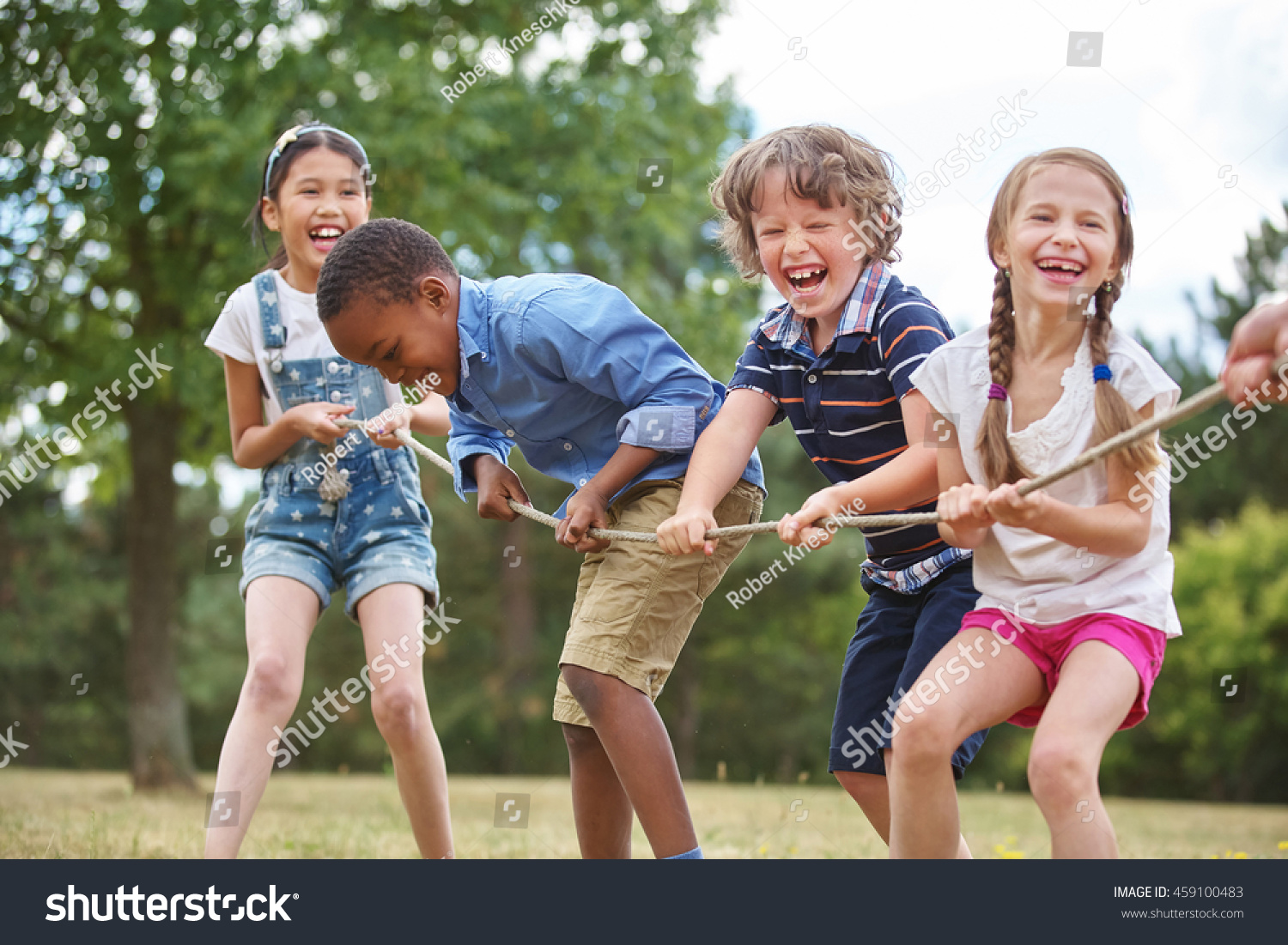 Children playing tug of war at the park #459100483