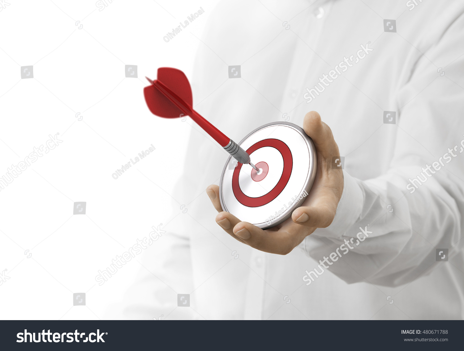 caucasian man holding a modern target with a dart in the center. image over white background. Concept of objective attainment. #480671788