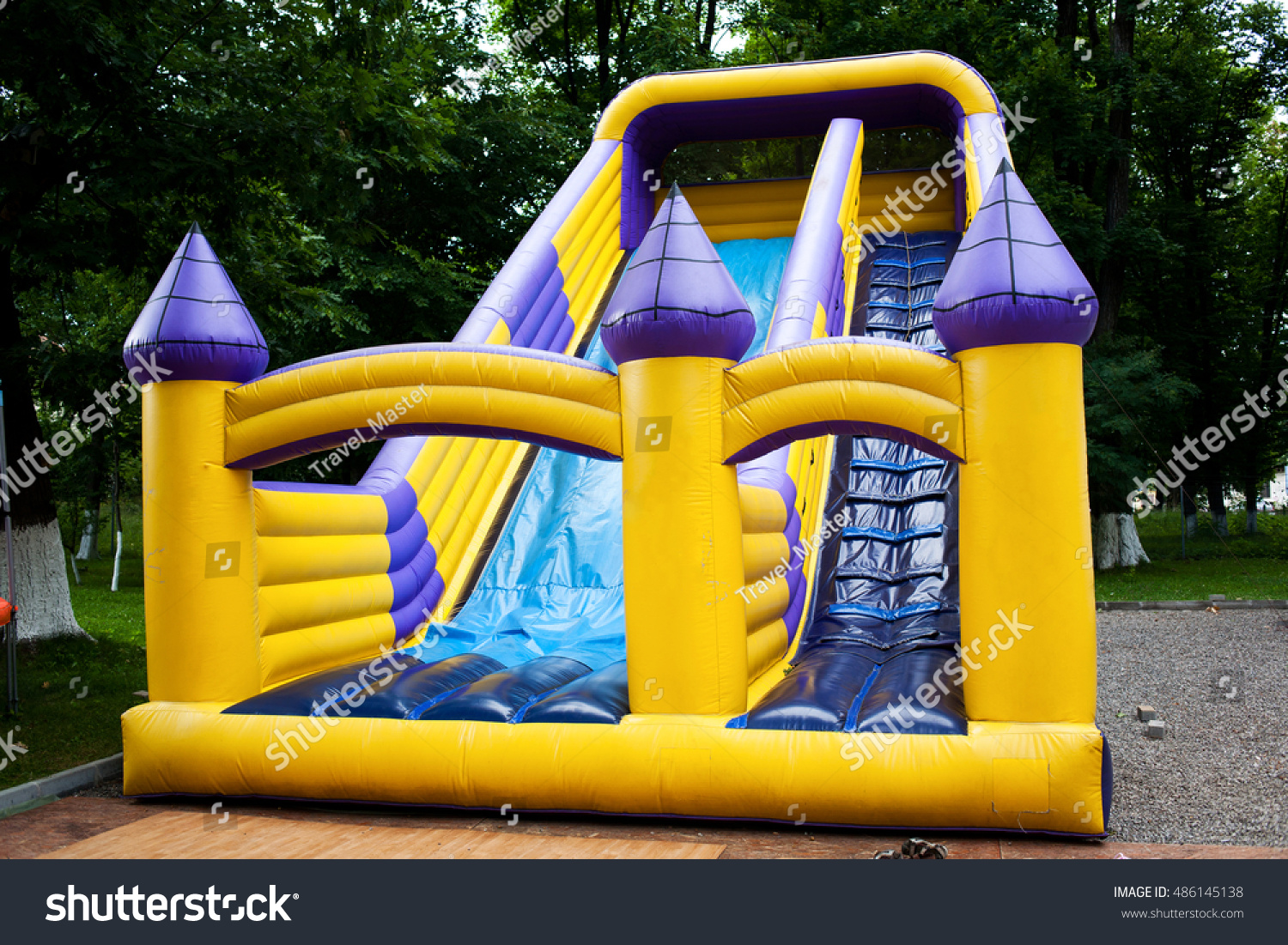 Inflatable big bouncy castle slide in a park #486145138