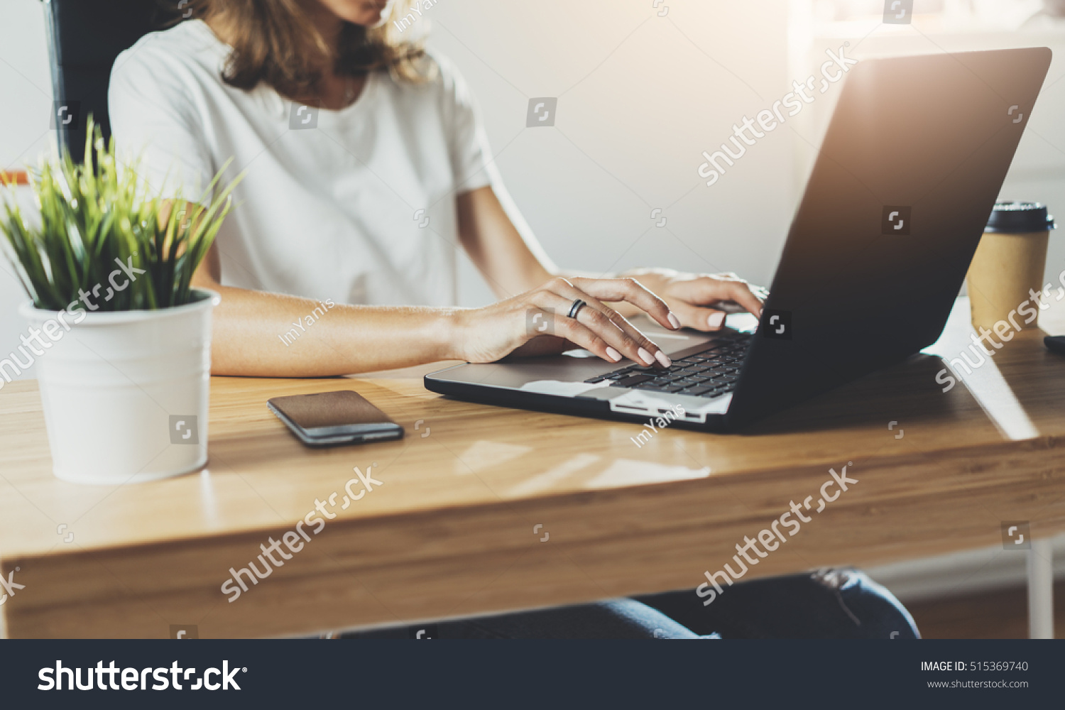 Cropped image of professional businesswoman working at her office via laptop, young female manager using portable computer device while sitting at modern loft, flare light, work process concept #515369740