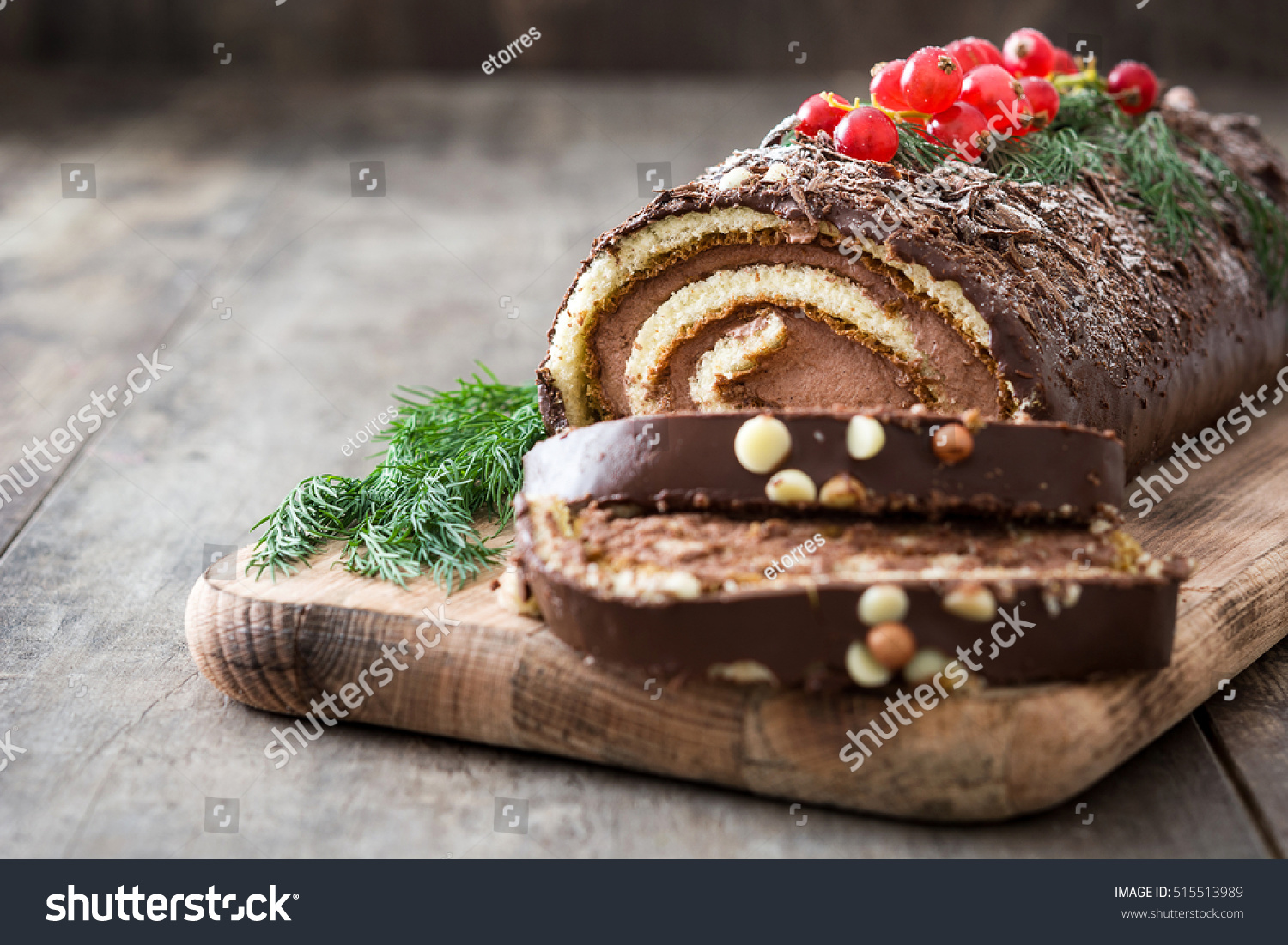 Chocolate yule log christmas cake with red currant on wooden background
 #515513989
