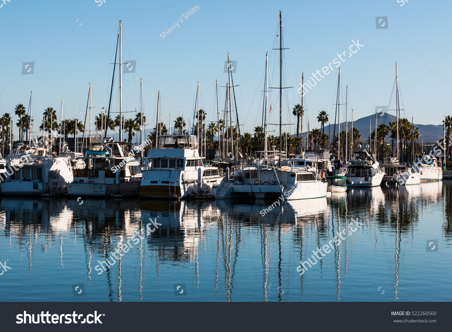 Boats moored in bay at the Chula Vista Bayfront park with mountain peak in the background. #522260560