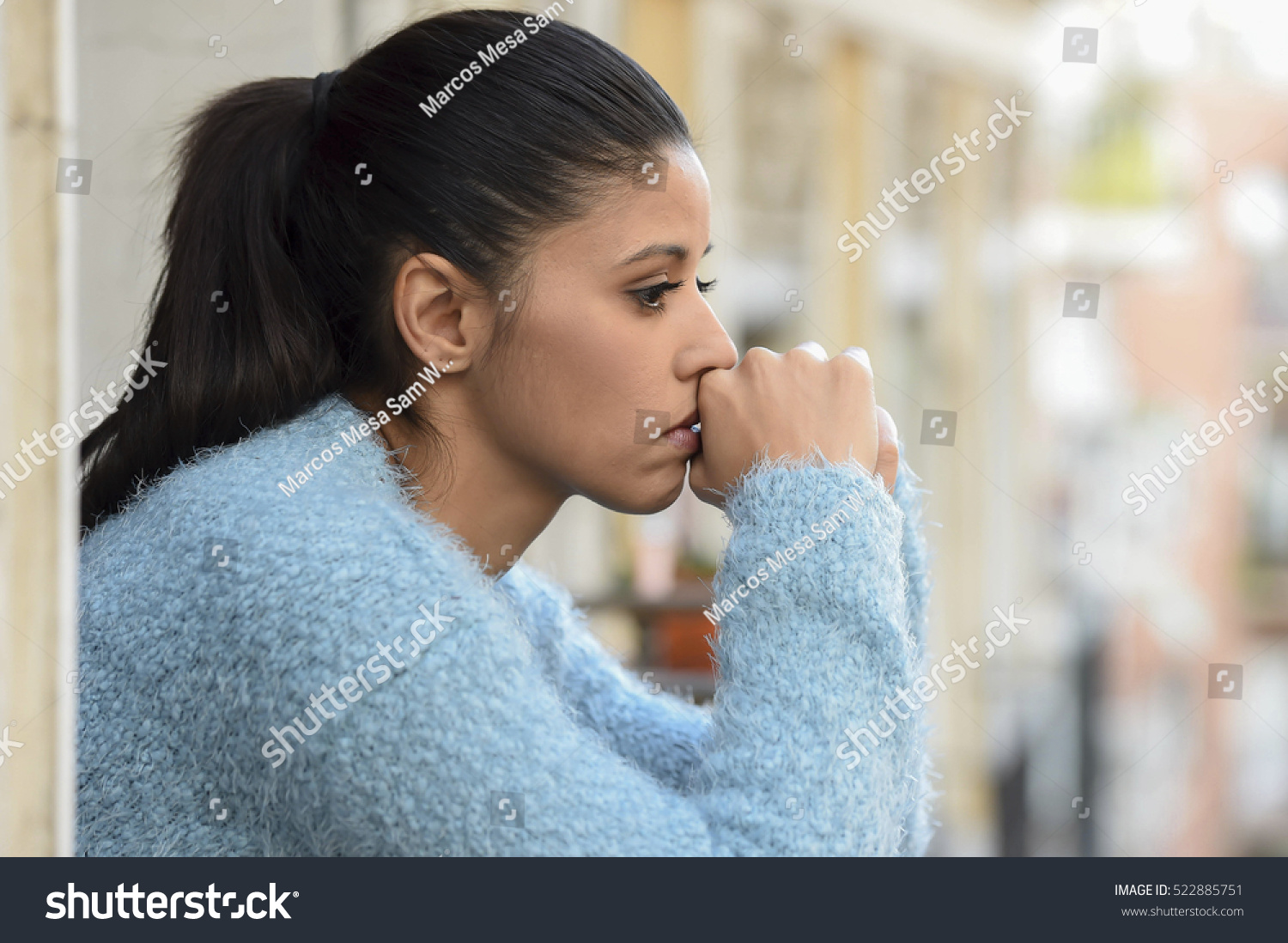 young beautiful sad and desperate hispanic woman suffering depression looking thoughtful and frustrated at apartment balcony looking depressed at the street  #522885751
