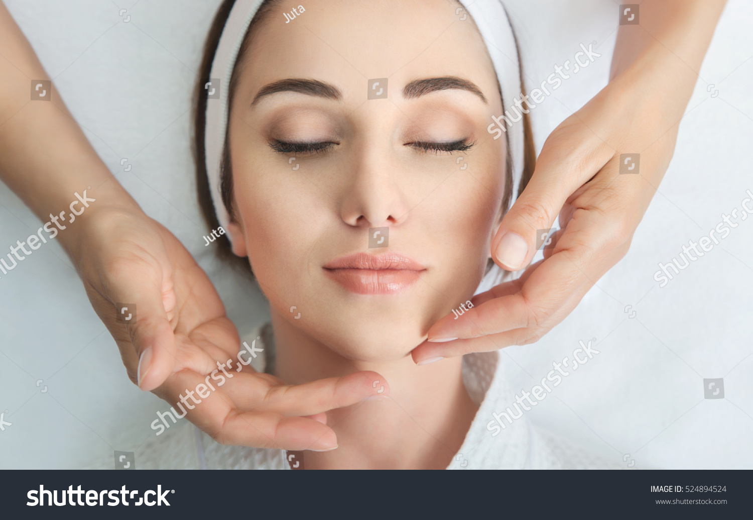 Face massage. Spa skin and body care. Close-up of young woman getting spa massage treatment at beauty spa salon. Facial beauty treatment. #524894524