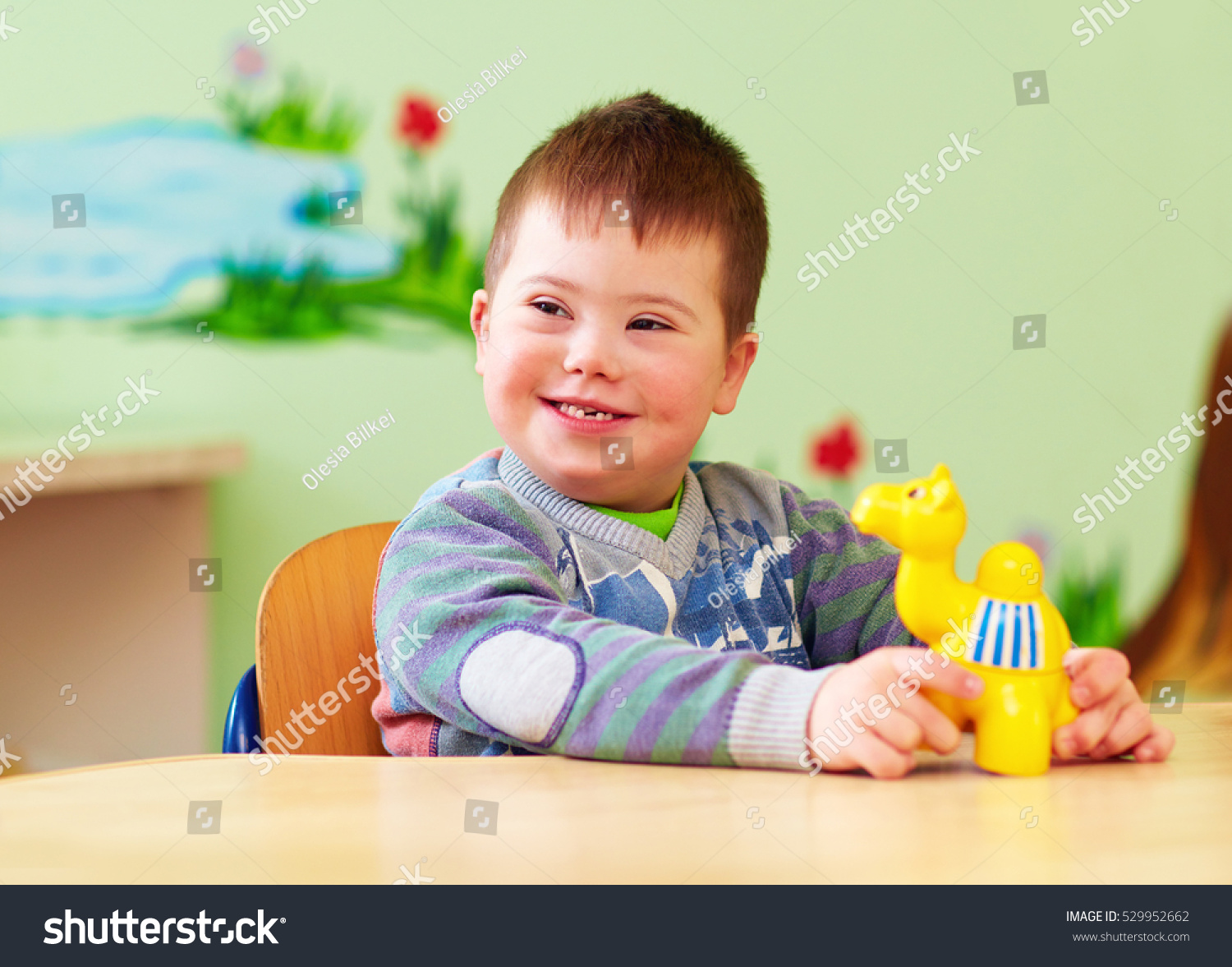 cute kid with down's syndrome playing in kindergarten #529952662