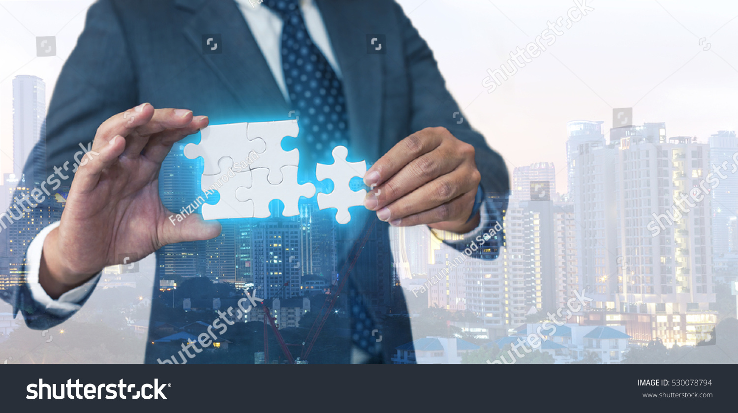Business solutions, success and strategy concept. Businessman hand connecting jigsaw puzzle. Double exposure and background down opacity. #530078794