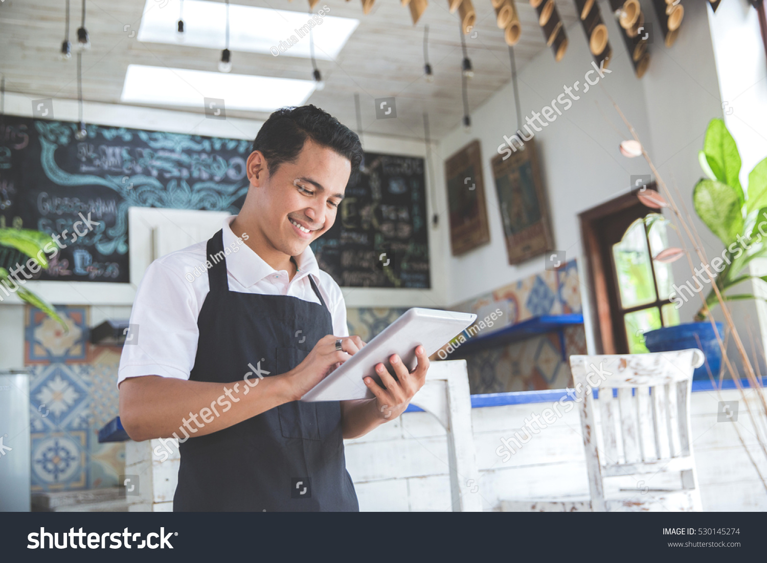 portrait of asian young male cafe owner with tablet #530145274