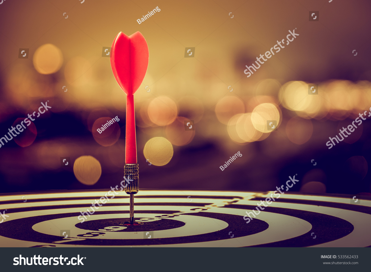 target dart with arrow over blurred bokeh background ,metaphor to target marketing or target arrow concept. #533562433