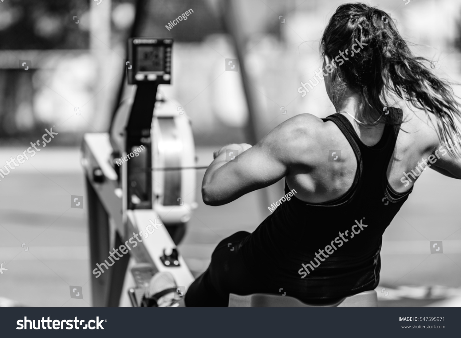 Female athlete on rowing machine on cross competition. #547595971