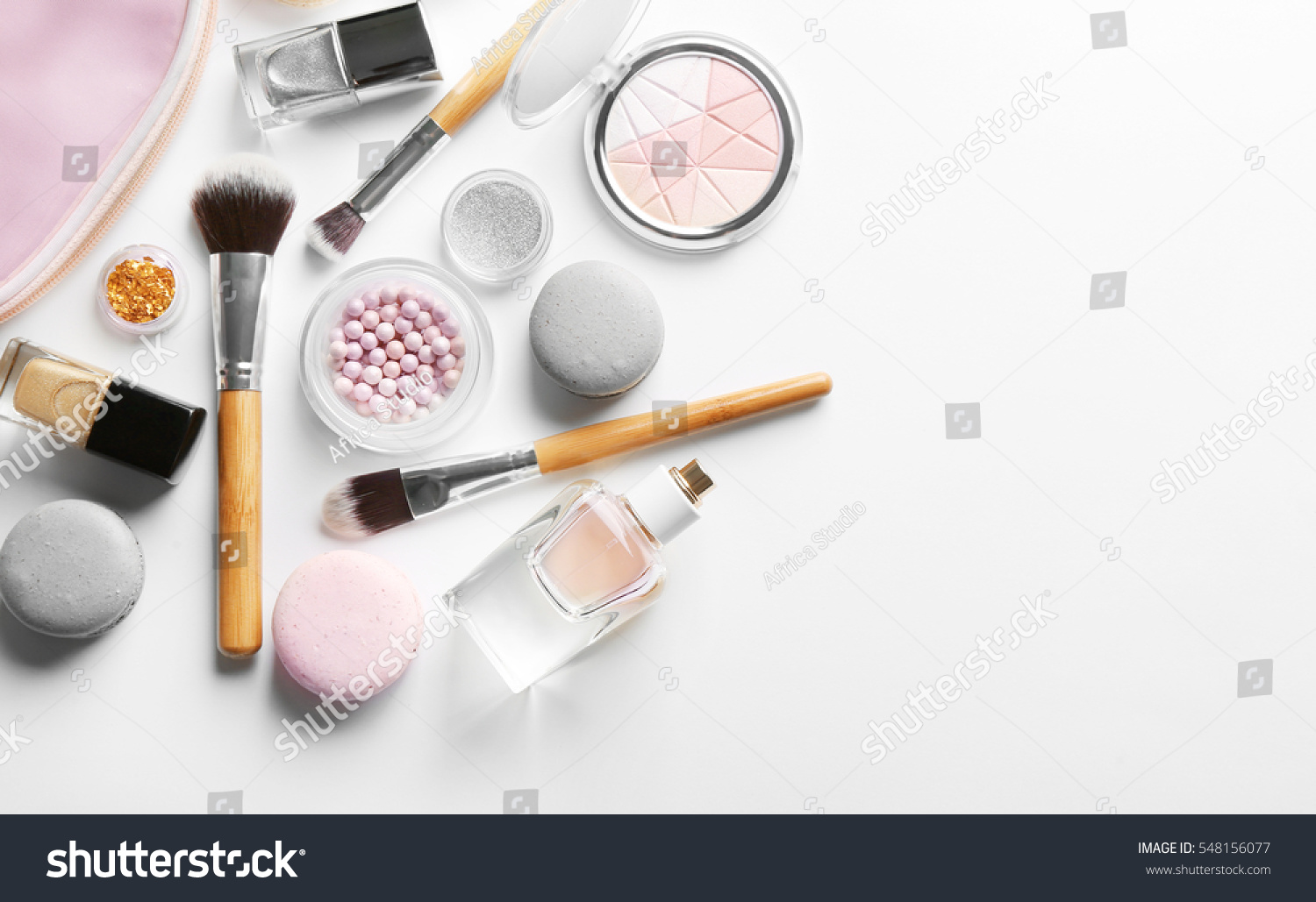 Makeup products with cosmetic bag and macaroons on light background #548156077