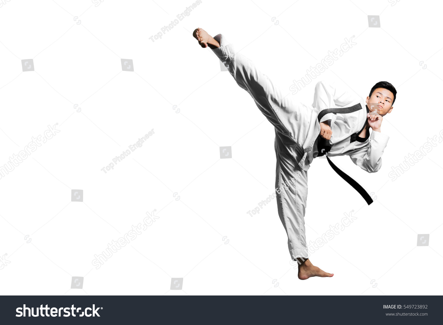 Portrait of a handsome asian man kick with taekwondo black belt . Isolated on white background with copy space #549723892