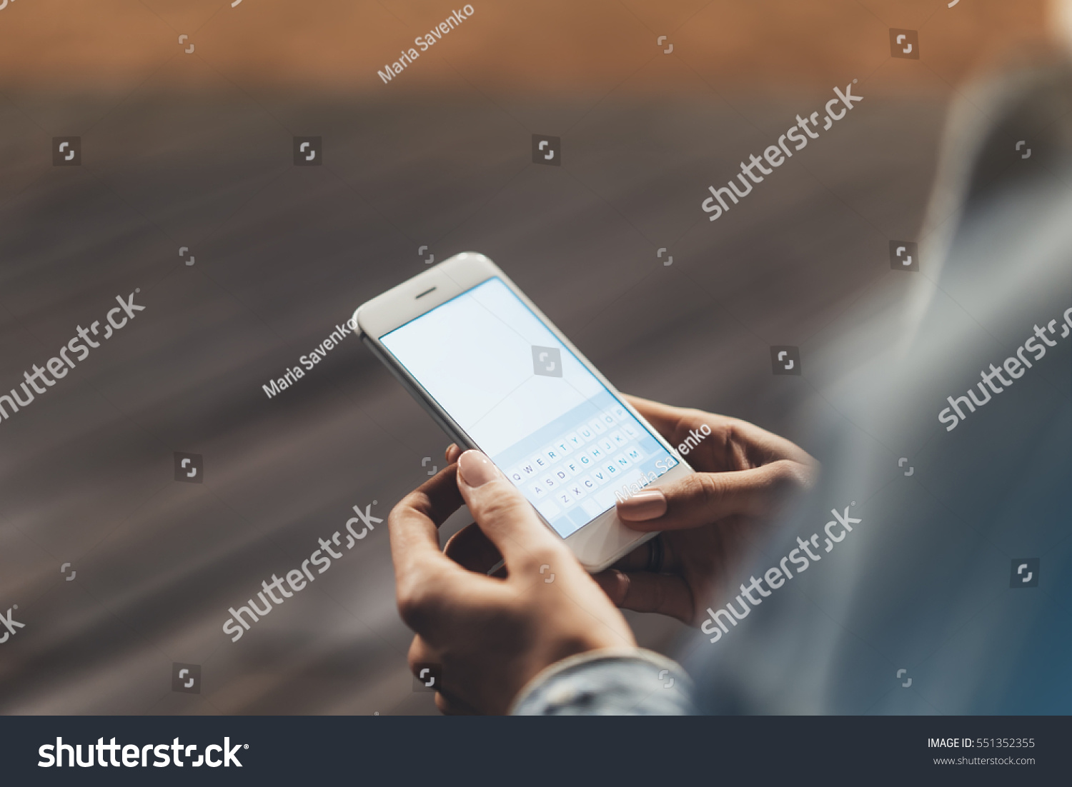 Girl pointing finger on screen smartphone on background wooden floor in night atmospheric city, hipster using in female hands and texting mobile phone, mockup glitter street lifestyle, blured backdrop #551352355