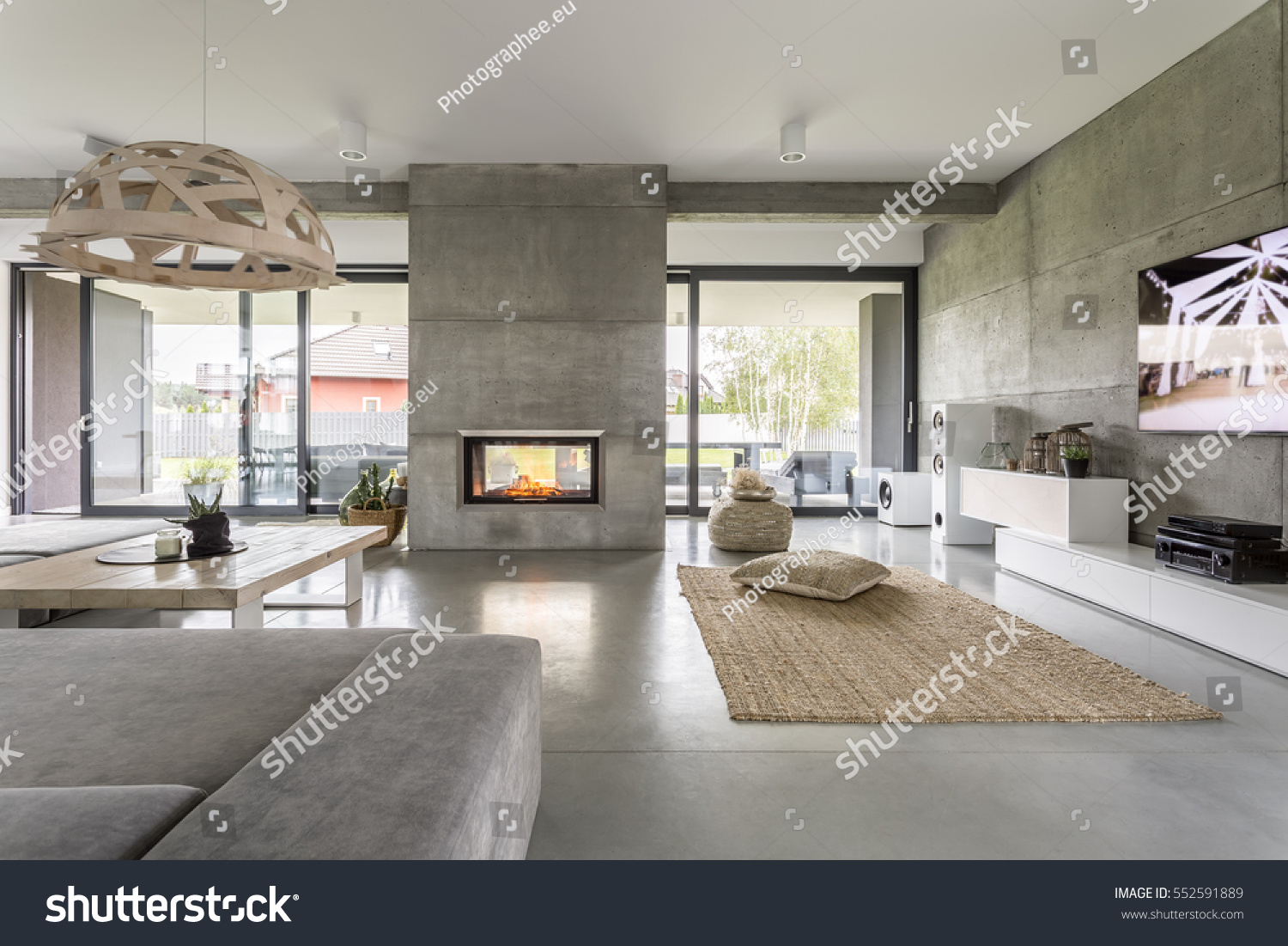 Spacious villa interior with cement wall effect, fireplace and tv #552591889