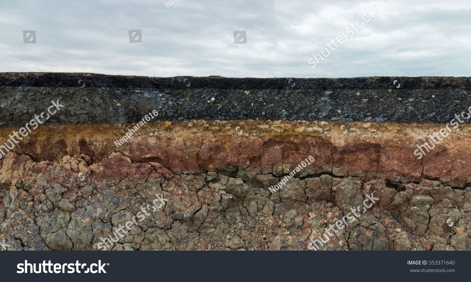 The layer of asphalt road with soil and rock. Un-focus image. #553371640