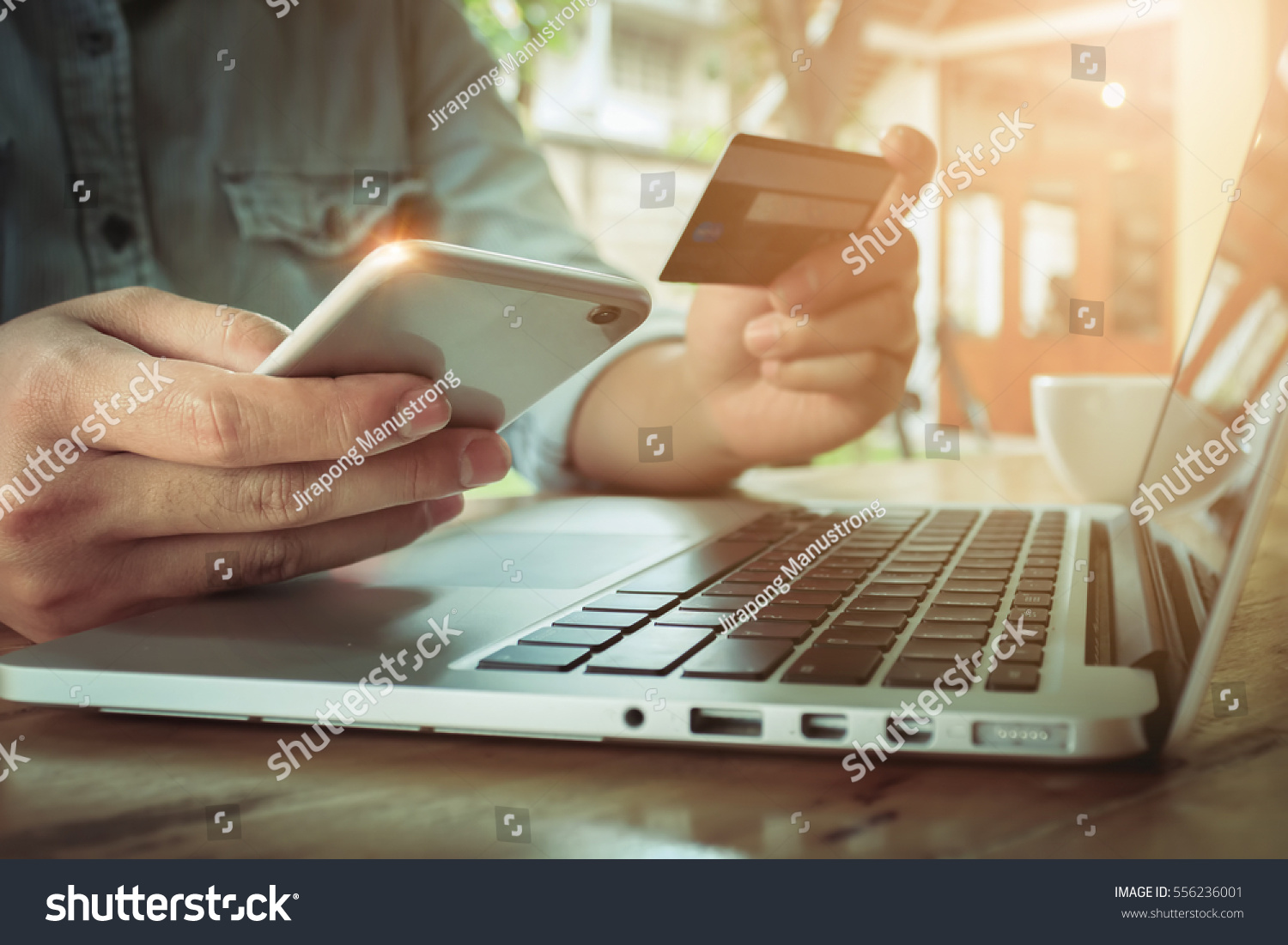 Online payment,Man's hands holding smartphone  and using credit card for online shopping. #556236001