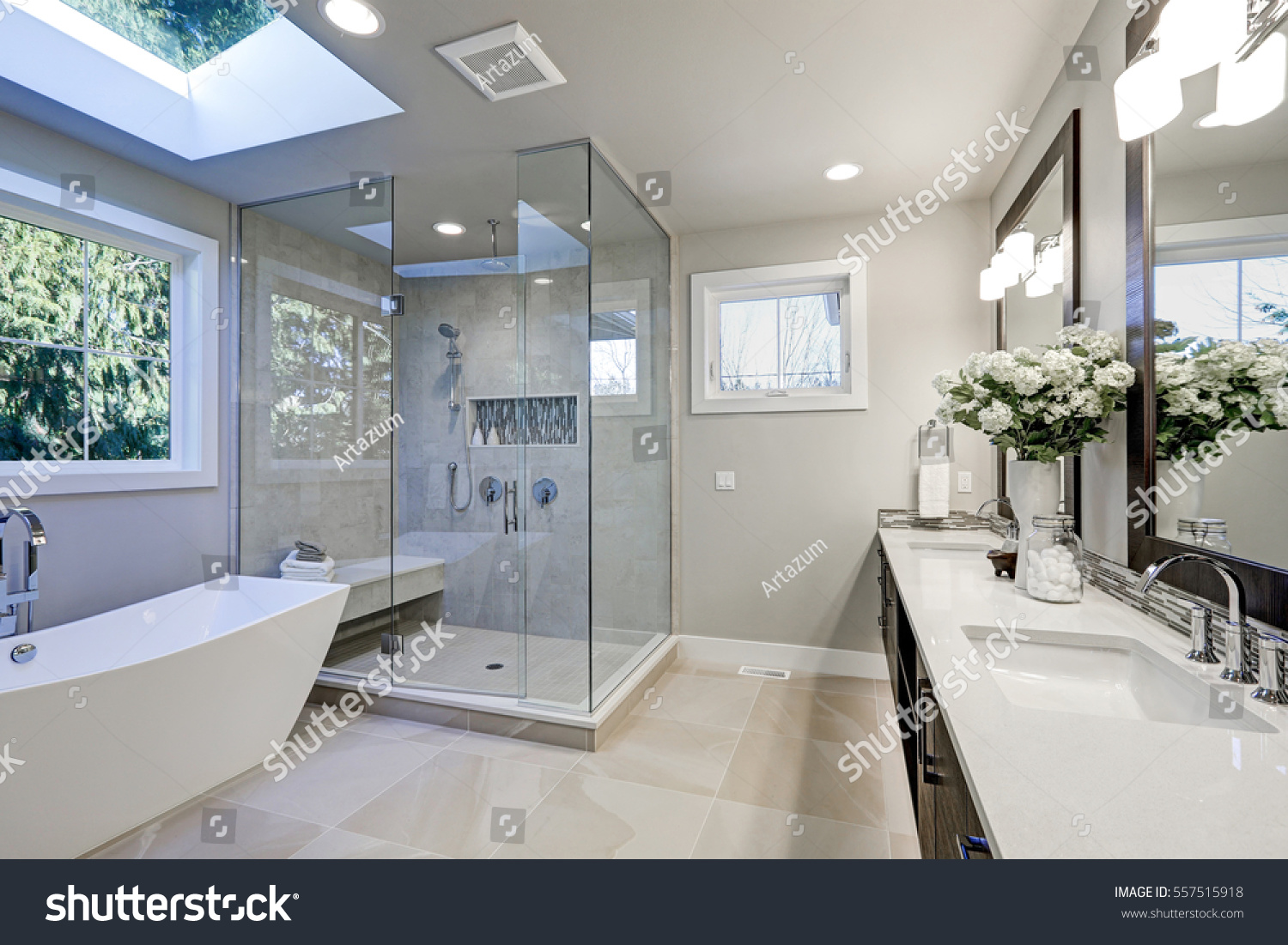 Spacious bathroom in gray tones with heated floors, freestanding tub, walk-in shower, double sink vanity and skylights. Northwest, USA #557515918