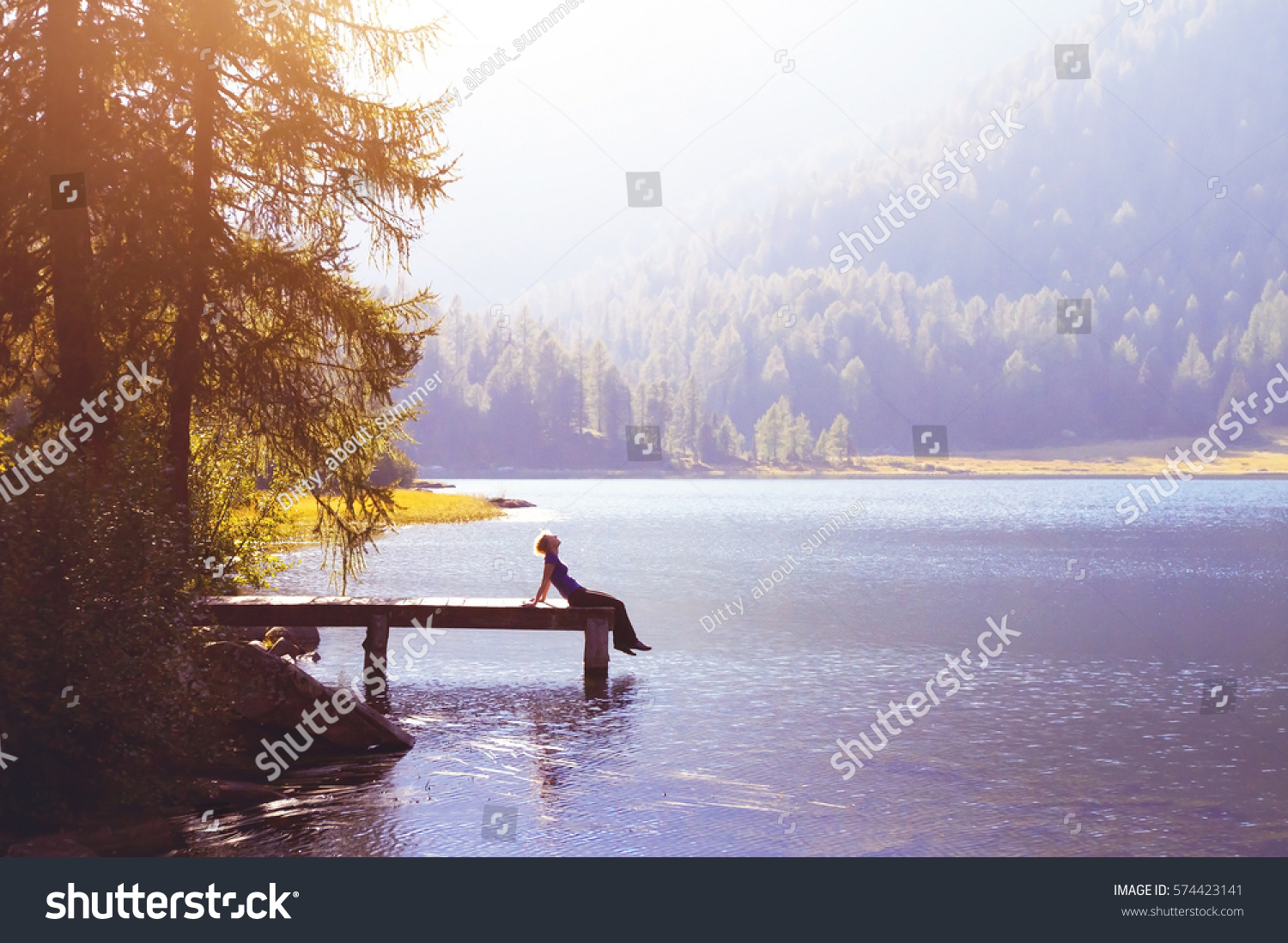 happy woman sitting on the pier and smiling, happiness or inspiration concept, enjoy life #574423141