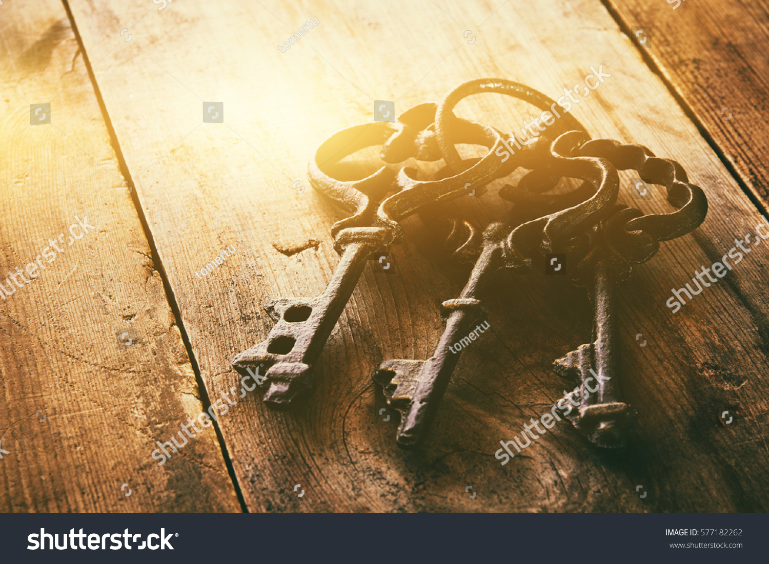 close up image of vintage skeleton keys over wooden table and bright light as revelation concept #577182262
