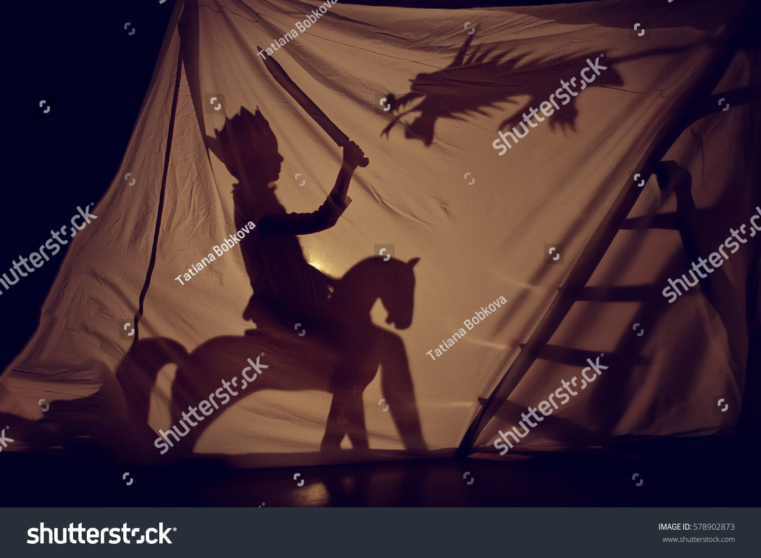 Fabulous the shadow of the little Prince on horse with sword and dragon. Theatre. Childhood. Tale. #578902873