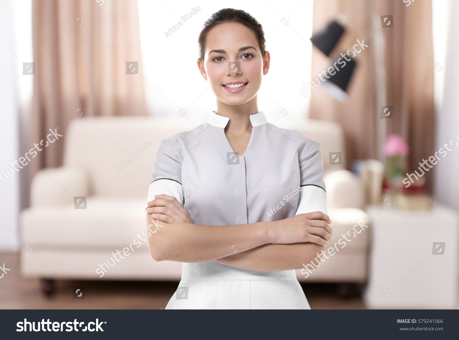 Chambermaid standing on living room background #579241066