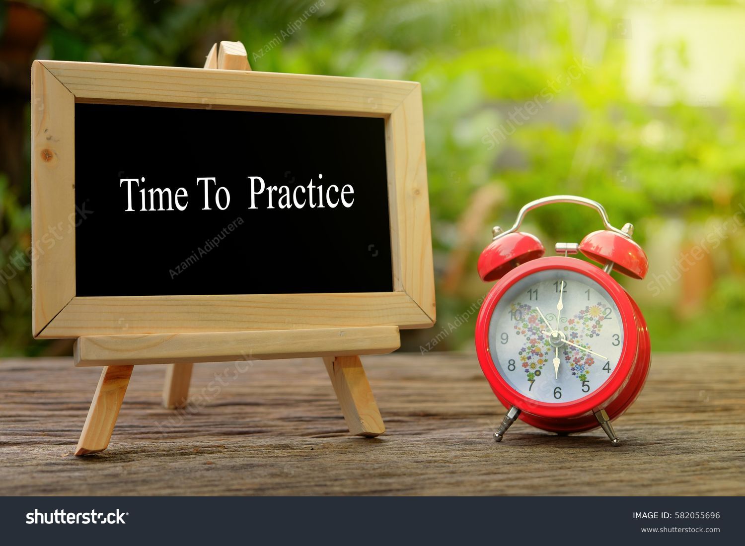 TIME TO PRACTICE! inscription written on chalkboard and red alarm clock on  old wooden desk . Time concept. #582055696