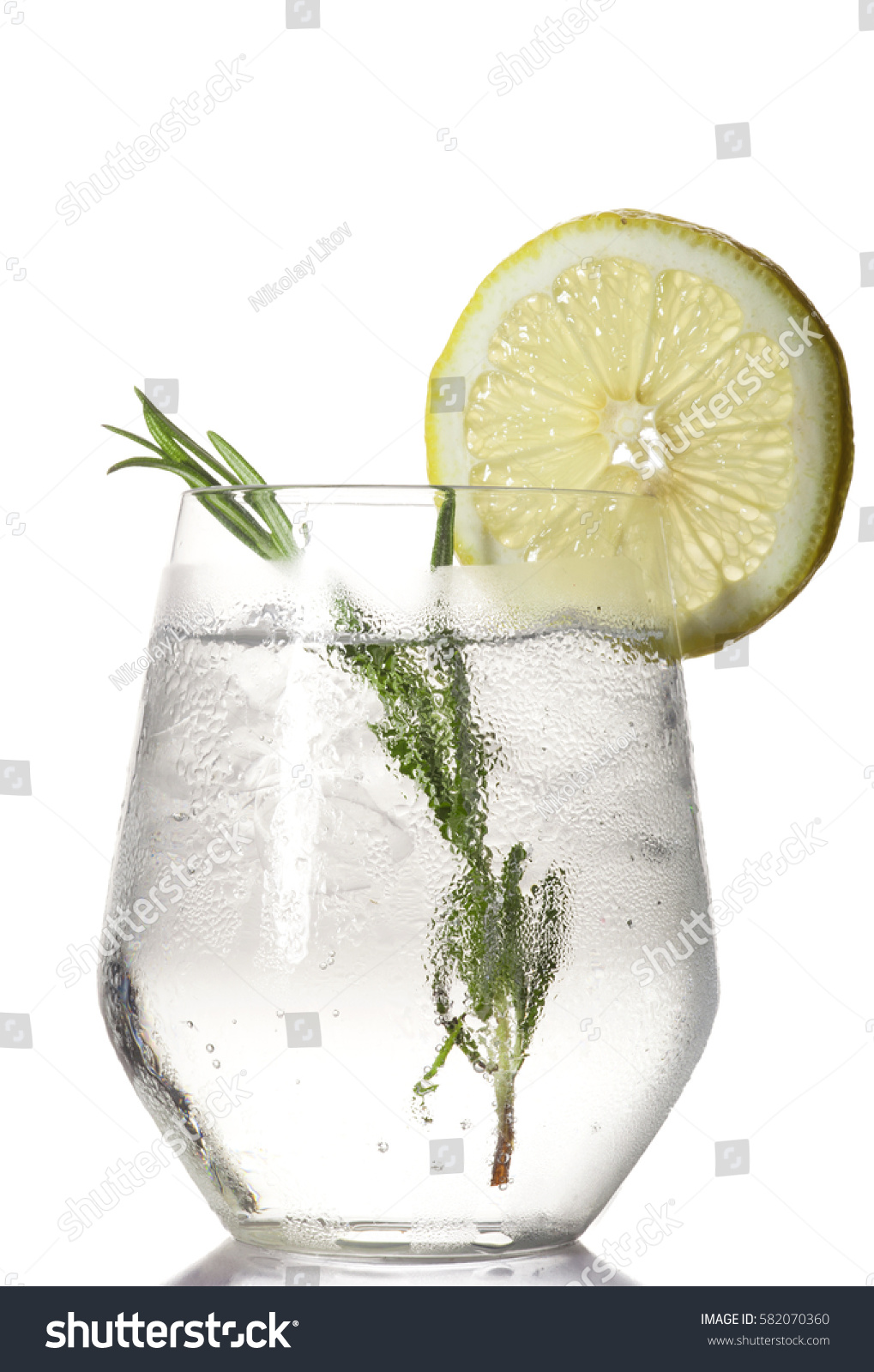 Glass with alcoholic drink with lime and ice isolated on white background. #582070360