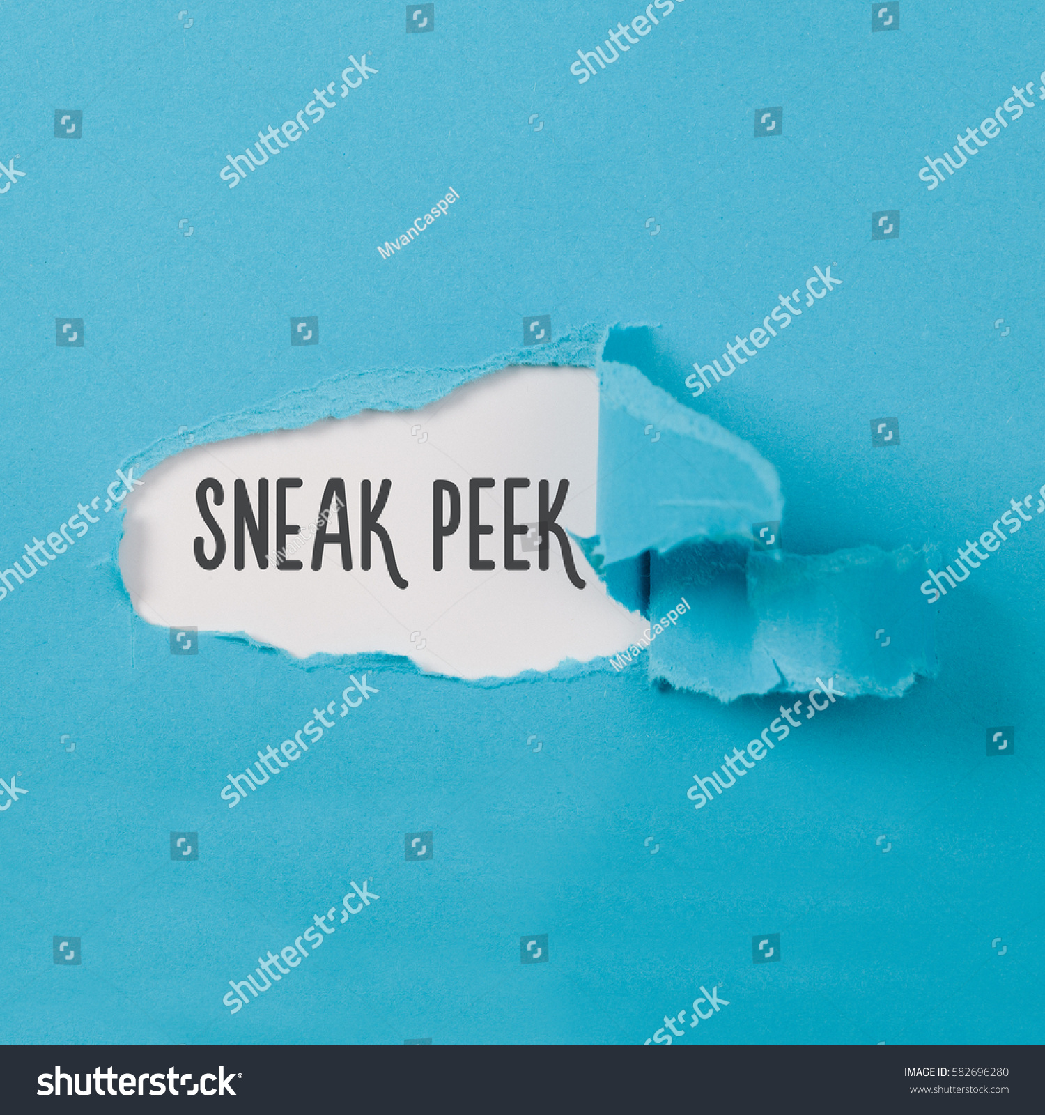 Sneak Peek message on torn blue paper revealing secret behind ripped opening. #582696280